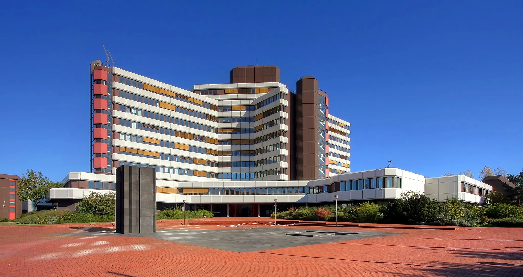 Photo showing: Head office of the Federal Office of Administration in Cologne, along Barbarastraße/Amsterdamer Straße. Year: 1984. Architect and construction firm: Hauptbauleitung (HBL) Köln, Finanzbauverwaltung NRW.
Foreground, sculpture "Lichtdurchlässige Bündelsäule" by Erwin Heerich, 1979.