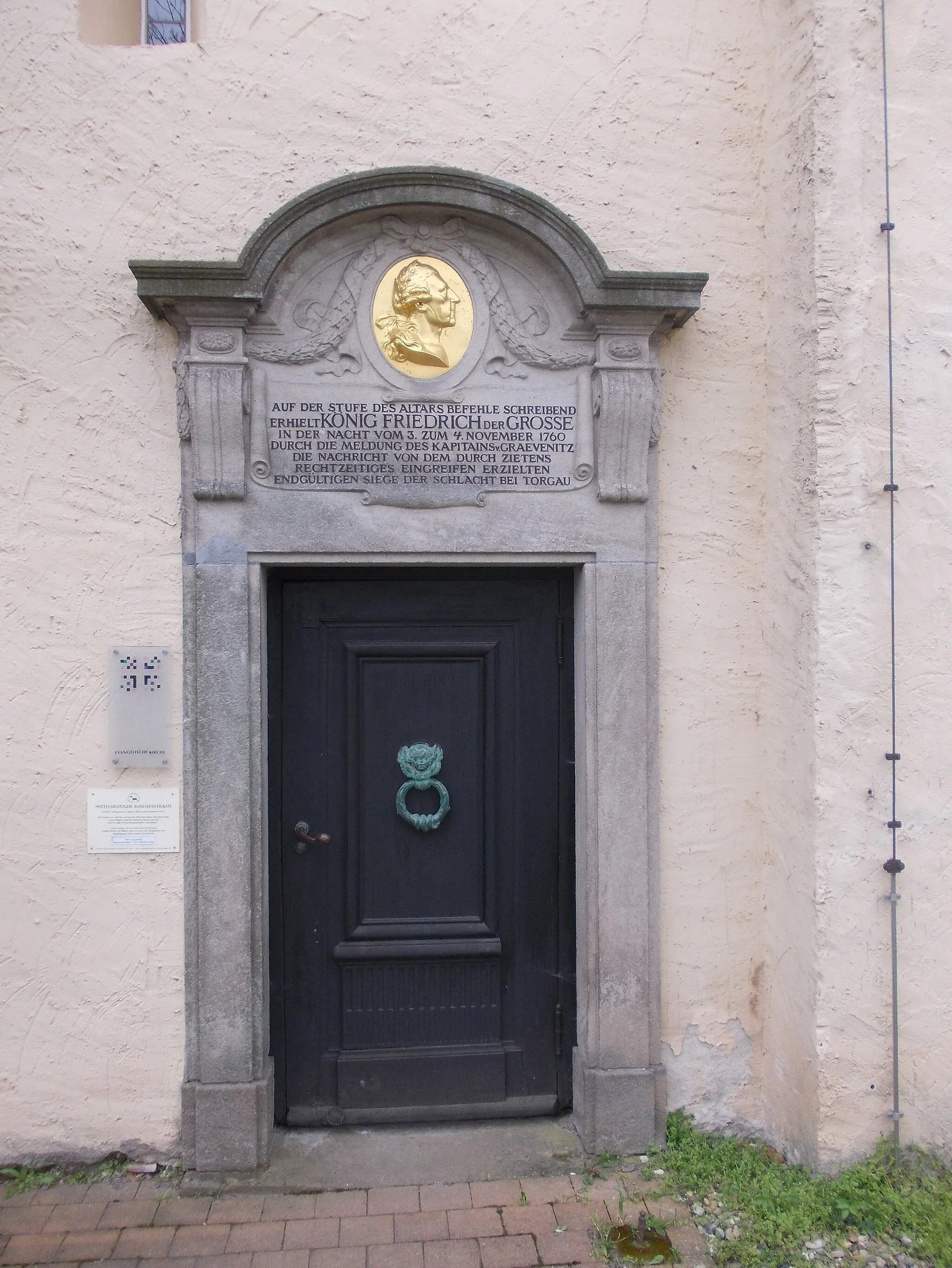 Photo showing: Elsnig church (Nordsachsen district, Saxony), portal with inscription commemorating the stay of Frederick II of Prussia during the Battle of Torgau in 1760