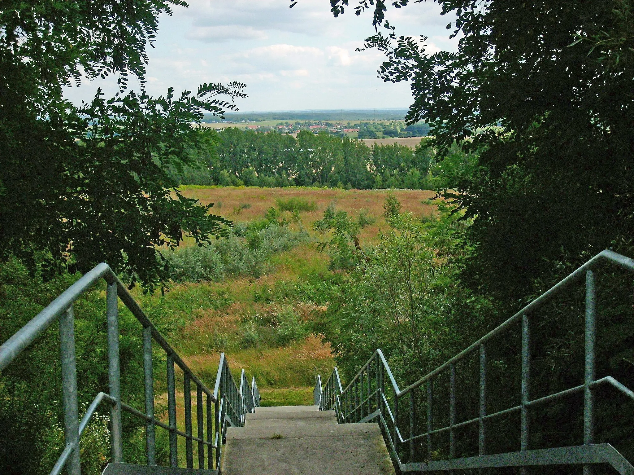 Photo showing: Stairway at the southern access to the Trages slag-heap, with the village of Thierbach (Kitzscher, Leipzig district, Saxony) in the background
