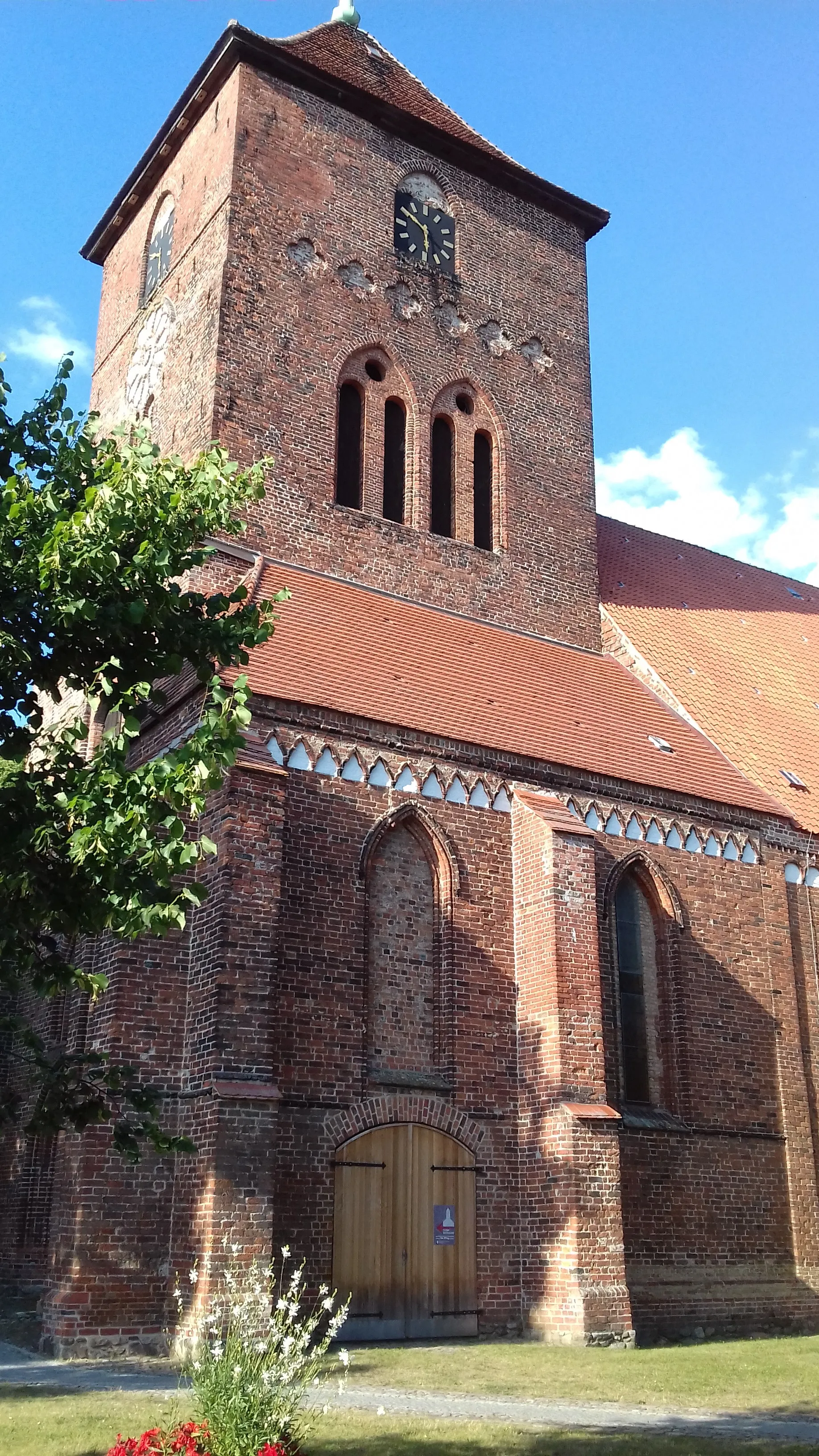 Photo showing: Die evangelisch-lutherische Kirche ist ein dreischiffiger gotischer Backstein-Hallenbau, dessen älteste Teile vermutlich aus der 2. Hälfte des 13. Jahrungderts stammen. Um 1300 wurde der quadratische Turm erreichtet. Ursprünglich besaß die dreijochige Kirche einen quadratischen Chor. 1870 bis 1872 wurde der alte Chor abgebrochen und ein größerer neugotischer Chor nach Plänen des Baumeisters Adolf Gädt gebaut. Gleichzeitig entstand ein nördlicher Kreuzarm, dessen Abriss 1972 erfolgte. Ältestes Stück der Kirche ist ein spätromanischer Taufstein aus gotländischem Sandstein aus den ersten Jahrzenten des 13. Jahrhunderts, der erst 1966 wieder im Chor aufgestellt wurde. 1872 erhielt die Kirche eine Friese-Orgel. Der Turm, dessen Höhe bis zum Stadbrand 1659 ca. 92m betragen und zuvor den Seefahrern auf der Ostsee als Landmarke gedient haben soll, ist heute mit seiner Spitze immerhin noch 45m hoch.