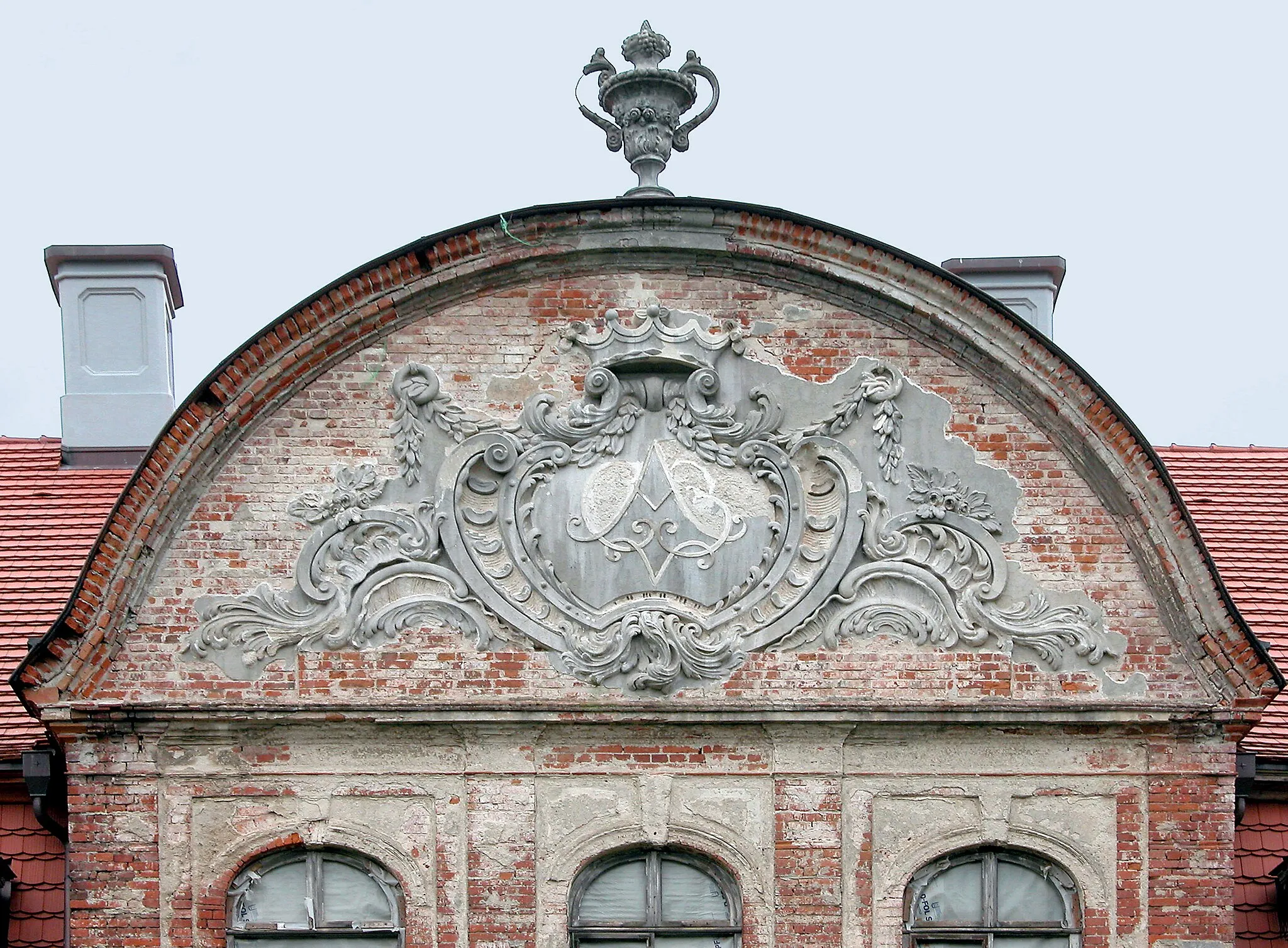 Photo showing: 26.06.2004   17019   Gützkow (Röckwitz), Dorfstraße (GMP: 53.725074,13.106744): Barockes Schloß als Herrenhaus des einstigen Ritterguts. Das symmetrische Gebäudeensemble aus repräsentativem Herrenhaus und den flankierenden Kavaliershäusern bildet einen weitläufigen Ehrenhof. Das Gutshaus wurde bis 1777 im Barockstil durch Adam von Blücher errichtet. Im Zuge der Bodenreform wurde 1945 der letzte Besitzer Siegfried von Sydow enteignet. Im Haus wurden Wohnungen eingerichtet. Ab 1985 stand das Gebäude leer. 1998 erwarb Helmuth Freiherr von Maltzahn das Anwesen und begann mit dem Wiederaufbau. Parkseite. Ziergiebel mit dem in Rocaillen gefassten Monogramm A C v B des Bauherrn Adam Christoph von Blücher.                                                                                                                                                               [DSCN4229.JPG]20040625180DR.JPG(c)Blobelt