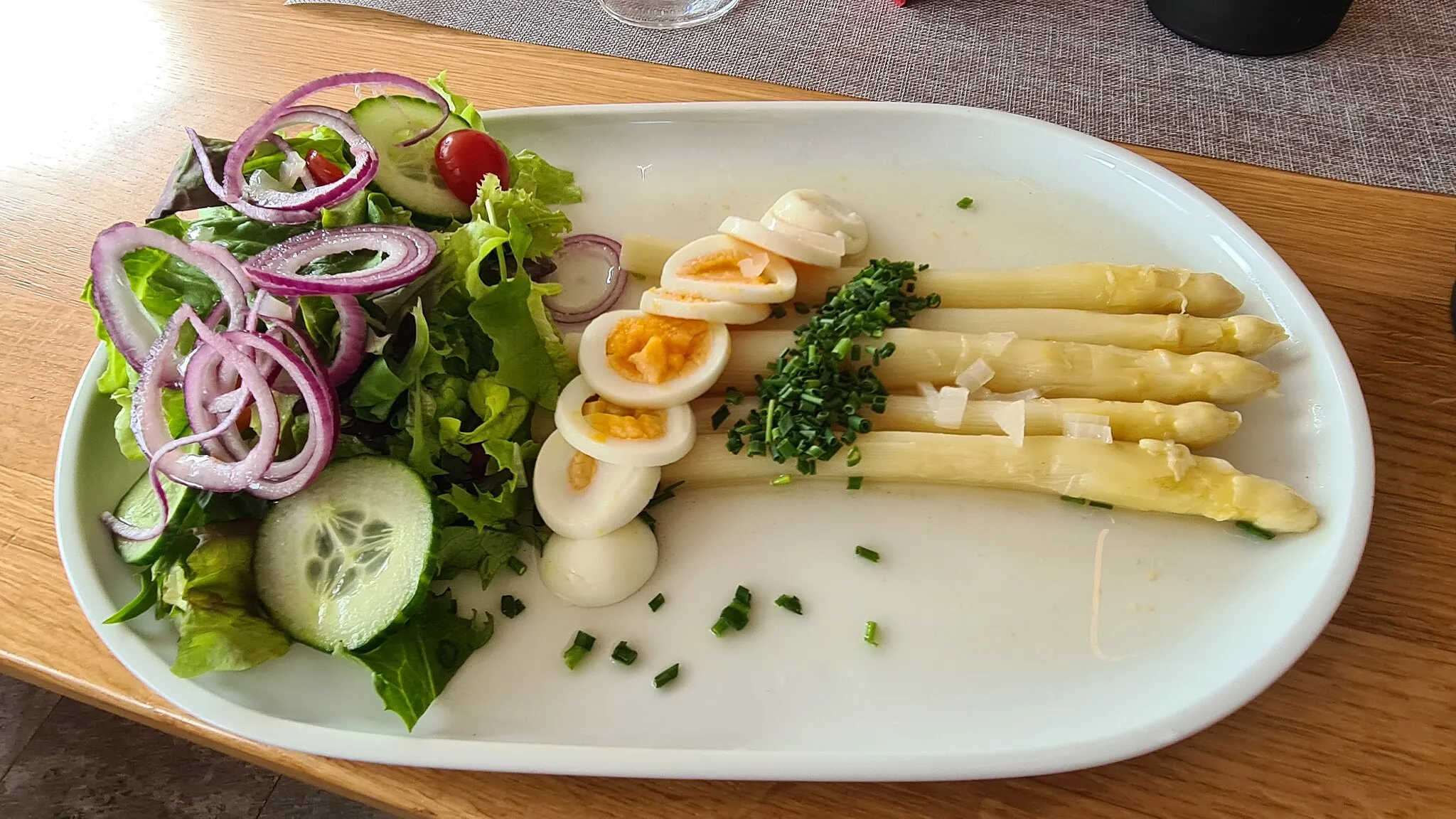 Photo showing: Asparagus salad, sliced hard boiled egg, finely chopped chives, vinagrette, served with a small mixed salad of lettuce, red onions cucumber slices and cherry tomato halves. Photographed at the Spezerei in Gundelsheim.