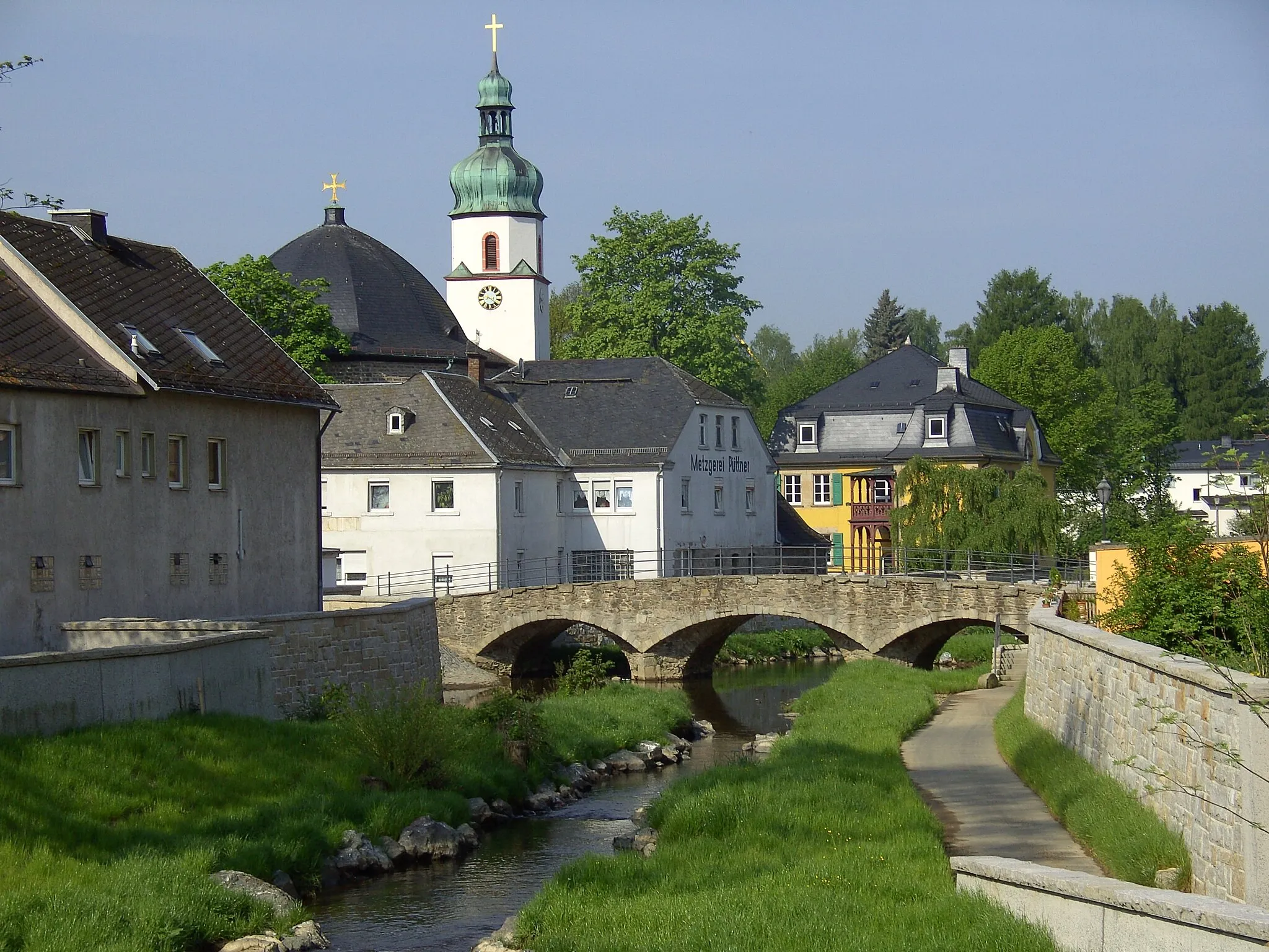 Photo showing: Oberkotzau: Brücke über die Schwesnitz, im Hintergrund die evangelische Kirche St. Jakobus mit Pfarrhaus