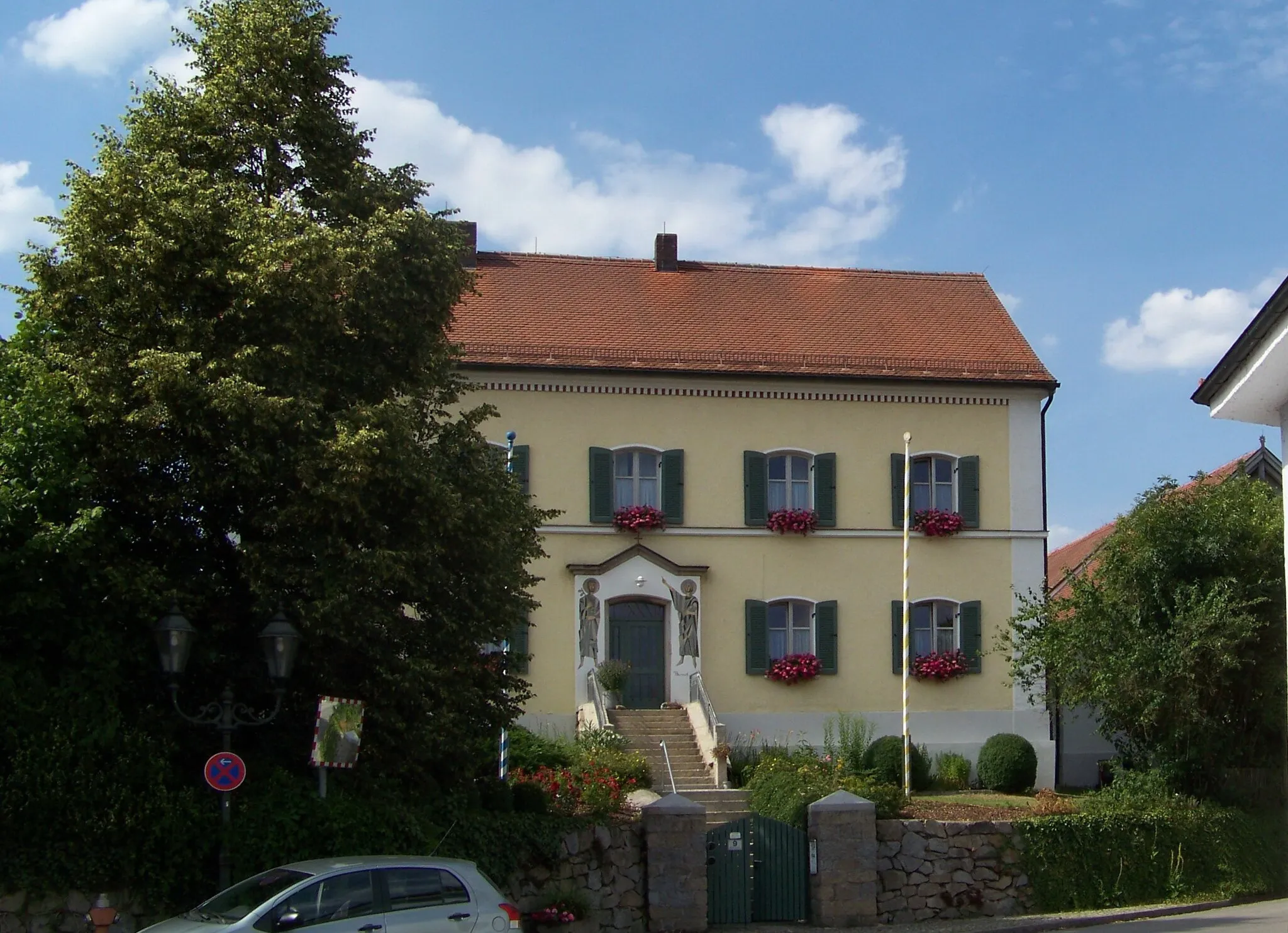 Photo showing: Chamerau, Chamer Straße 9, Pfarrhof mit Pfarrökonomie, regelmäßige Vierseitanlage, 1869/70; Pfarrhaus, zweigeschossiger und traufständiger Flachsatteldachbau.