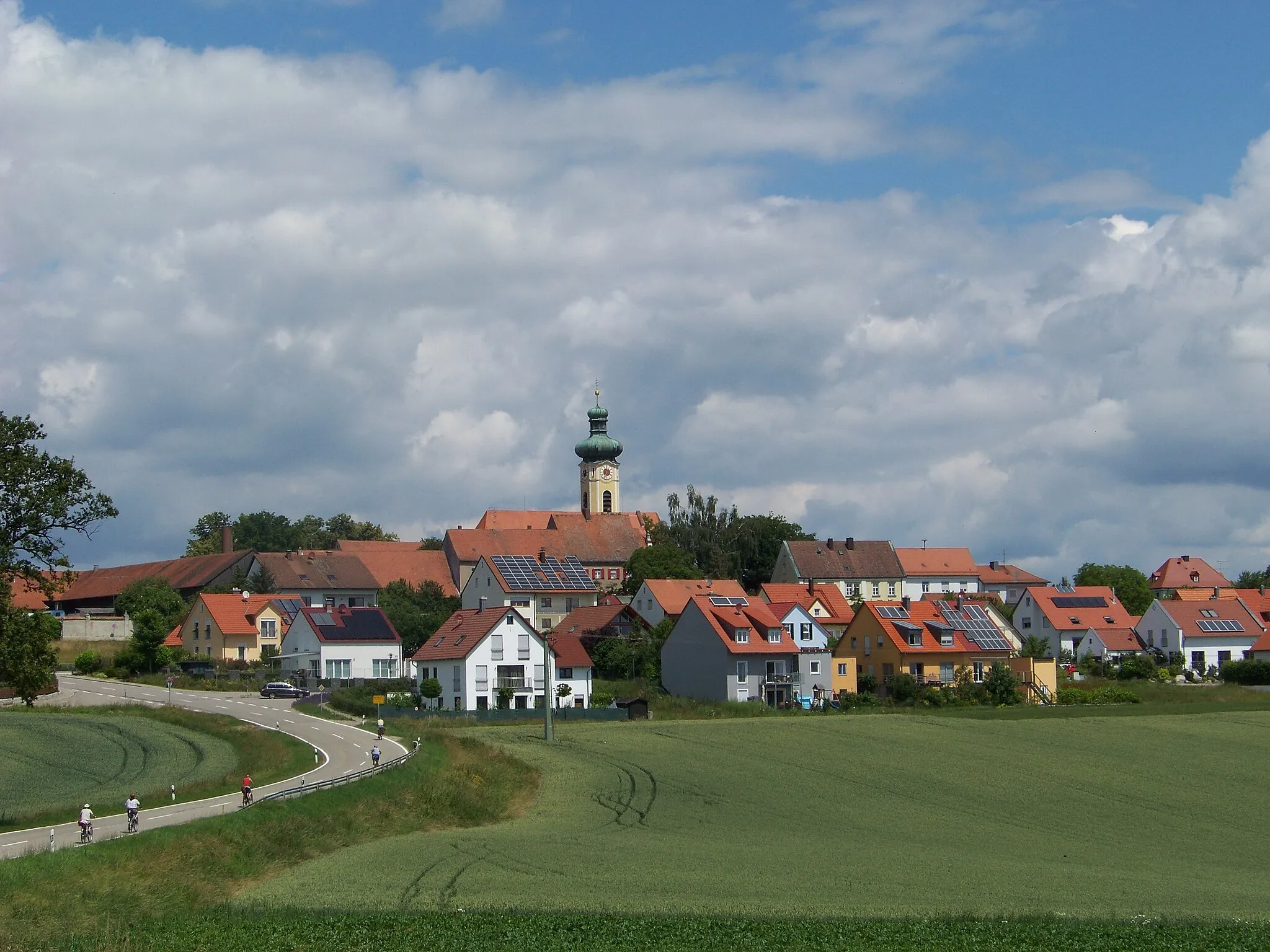 Photo showing: Pentling, Hohengebraching. Ortsansicht von Süden. In der Bildmitte die Kirche Mariä Himmelfahrt im neobarocken Baustil.