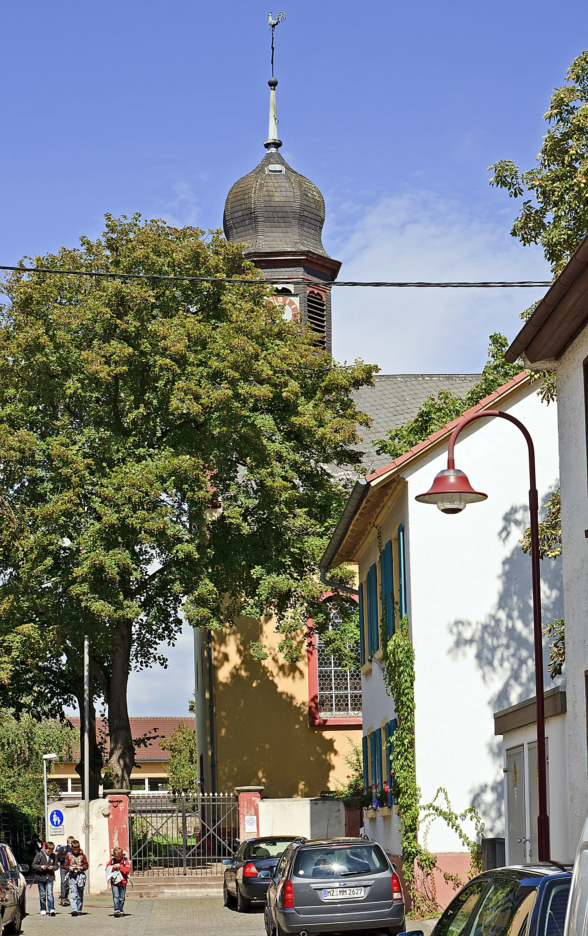 Photo showing: Gensingen, Blick in die Kirchgasse auf die evangelische Kirche. Die ehemalige Simultankirche, in der ein Hochaltar aus dem Jahr 1751 stand, wurde nach dem Bau der katholischen Pfarrkirche Jahr 1969 ausschließlich durch die evangelische Gemeinde genutzt.