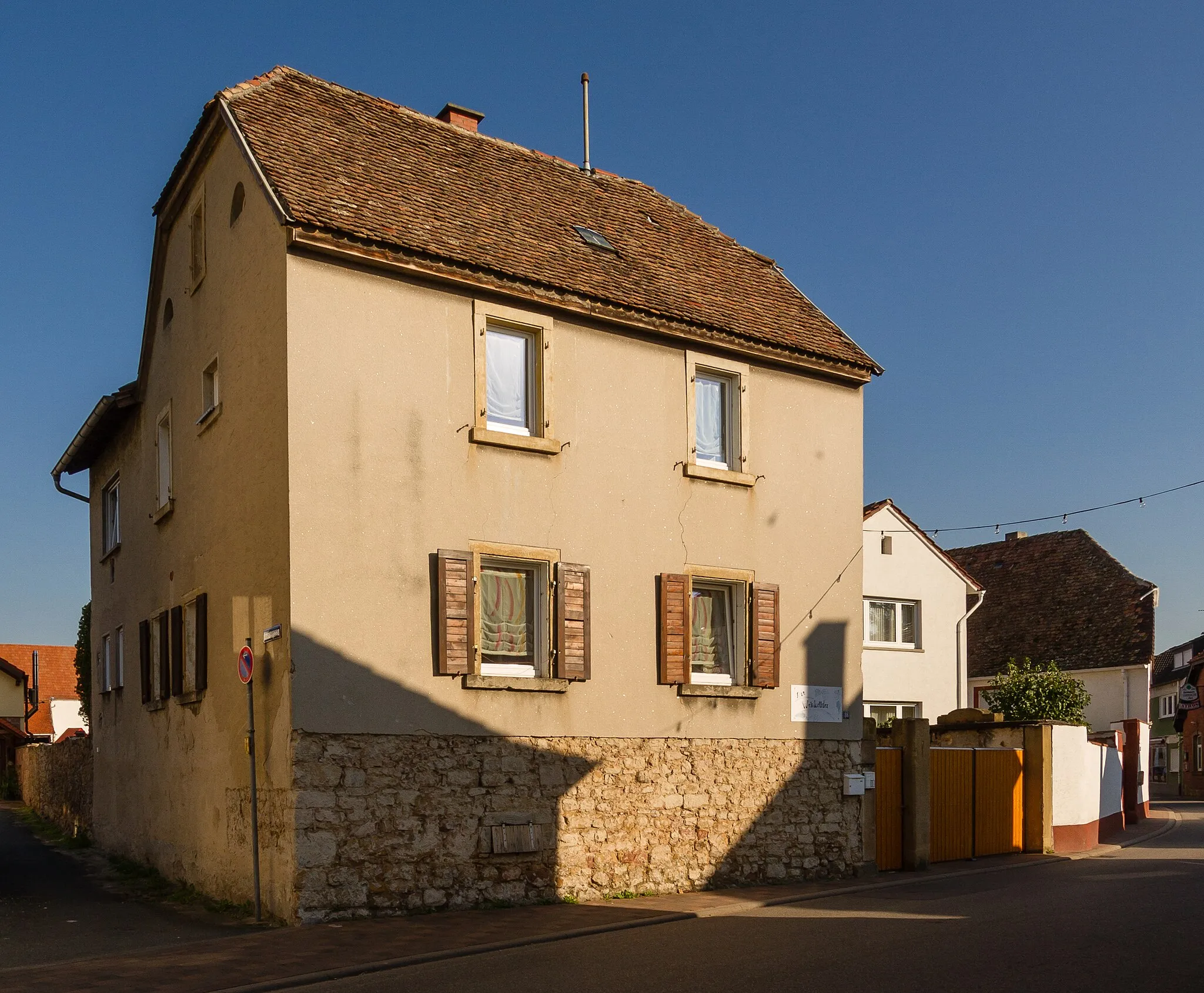 Photo showing: This is a photograph of a cultural monument. It is on the list of cultural monuments of Niederkirchen bei Deidesheim.
Designation: Double estate Location: Hauptstraße House number: 82, 84, 86 Place: Niederkirchen bei Deidesheim, District Bad Dürkheim, Rhineland-Palatinate, Germany Construction time: 18th centur Description: Three-winged late baroque double estate.
No. 82: late baroque semi-basement double house with half hipped roof, designated 1761.
No. 86: House, mid-19th century, on older cellar, possibly before the 18th century. Remains of the late gothic gateway, probably from the 16th century.
Former tithe barn, quarry stone building with half hipped roof, 18th century.
Complete structural composition