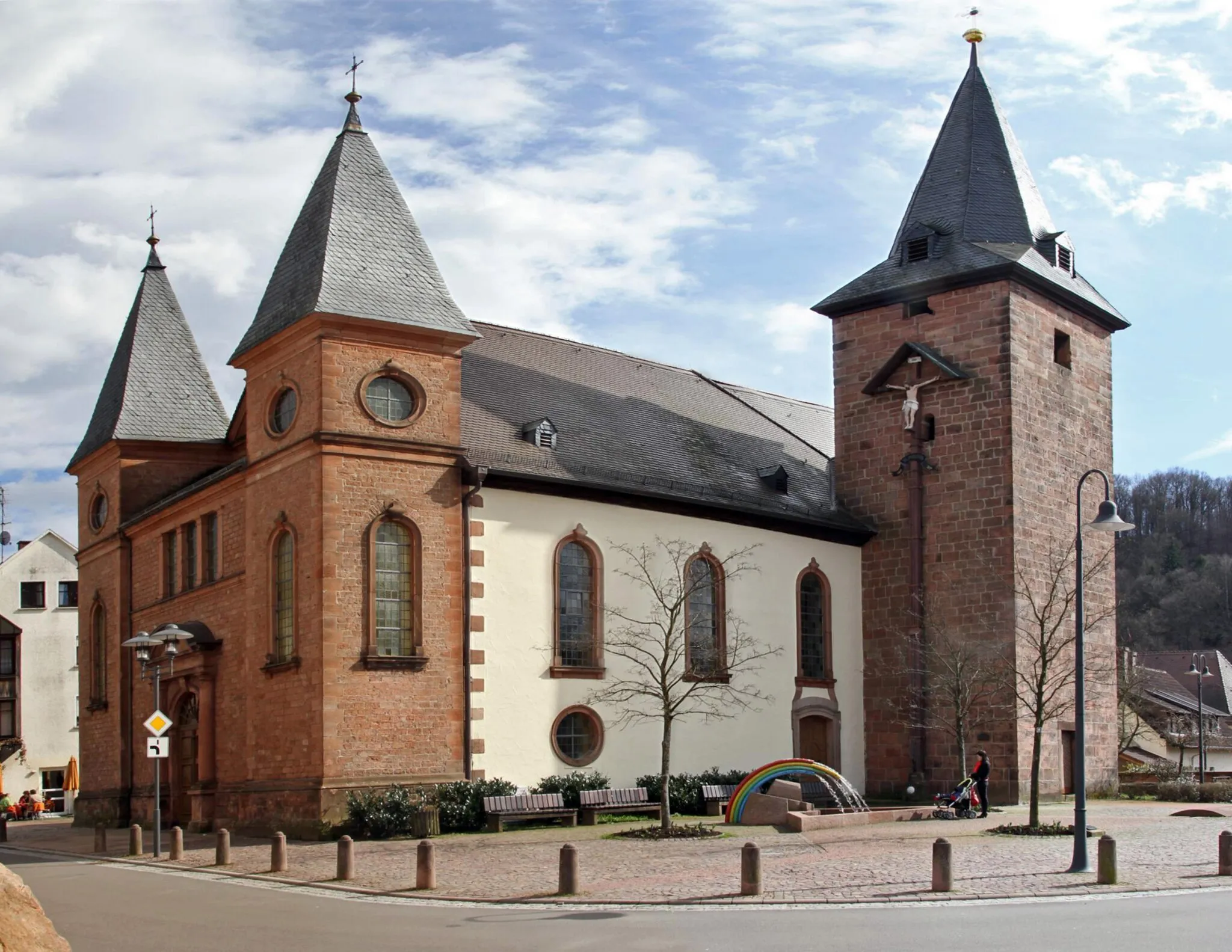 Photo showing: Rodalben, katholische Kirche Mariä Geburt, Hauptstraße 124. Alte katholische Pfarrkirche, romanischer Westturm und Ostchor mit Resten gotischer Wandmalerei. Barocker Saalbau mit Chor nach Süden, 1735. Nördliche Vorhalle mit zwei Türmen, 1886; Kruzifix, bezeichnet 1771 und 1894. Ansicht von Nordwesten.