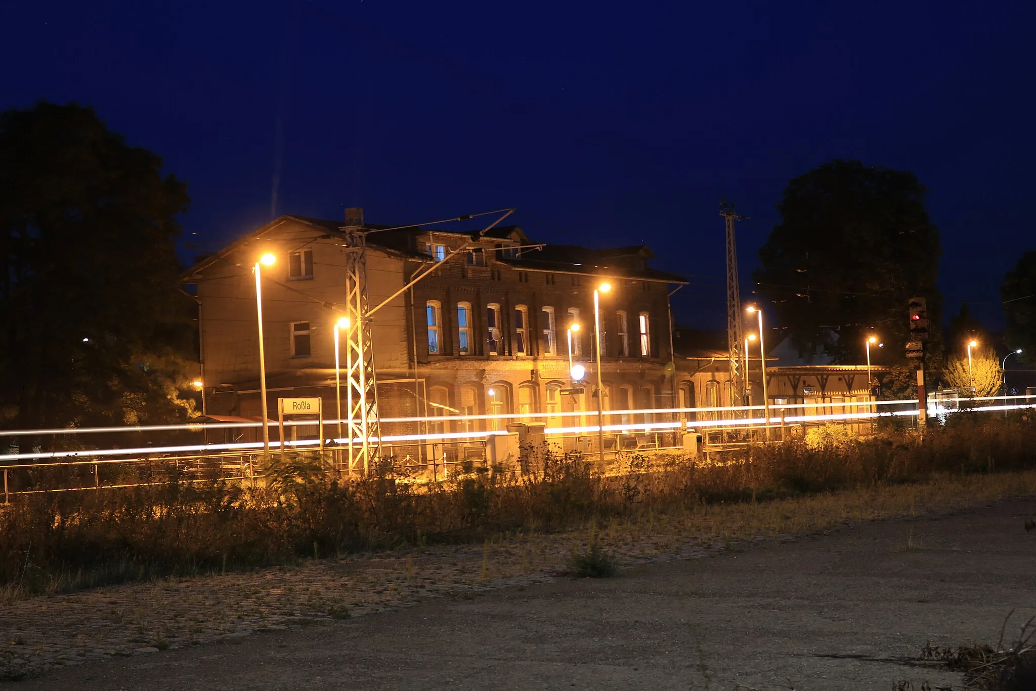 Photo showing: The building of the train station Roßla in Saxony-Anhalt, part of the railway line from Hannoversch Münden to Halle, at night.