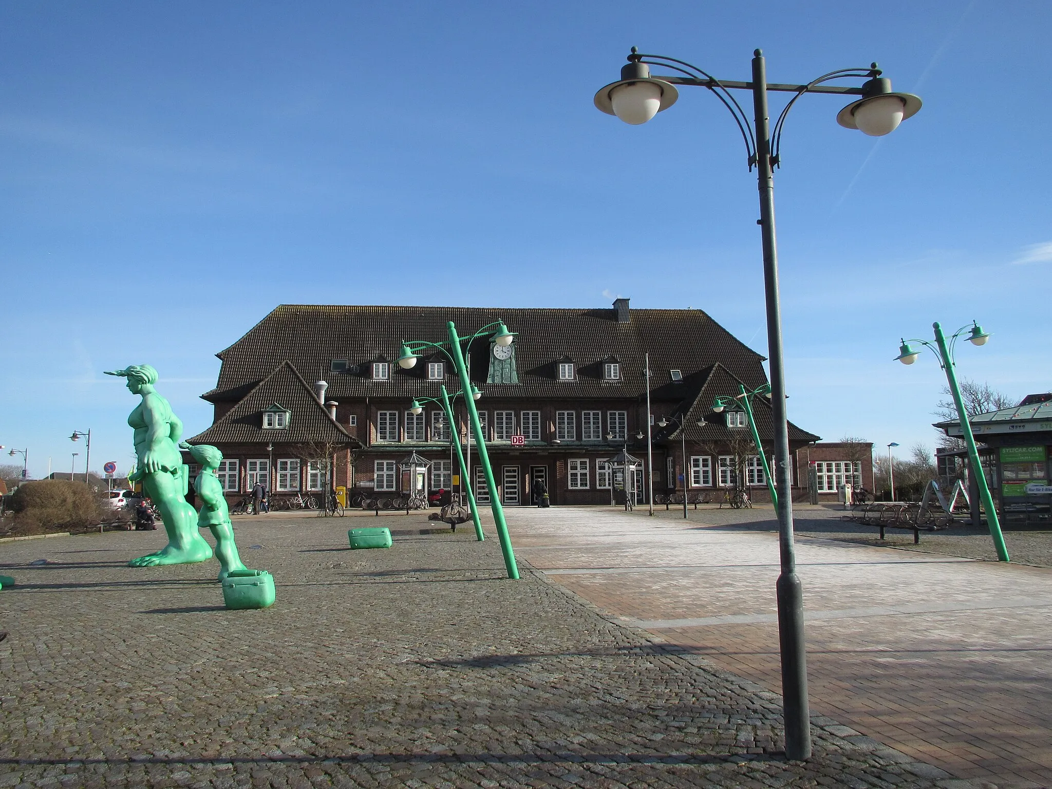 Photo showing: Sylt-Westerland-Bahnhof mit Skulptur Reisende im Wind von Bildhauer Martin Wolke