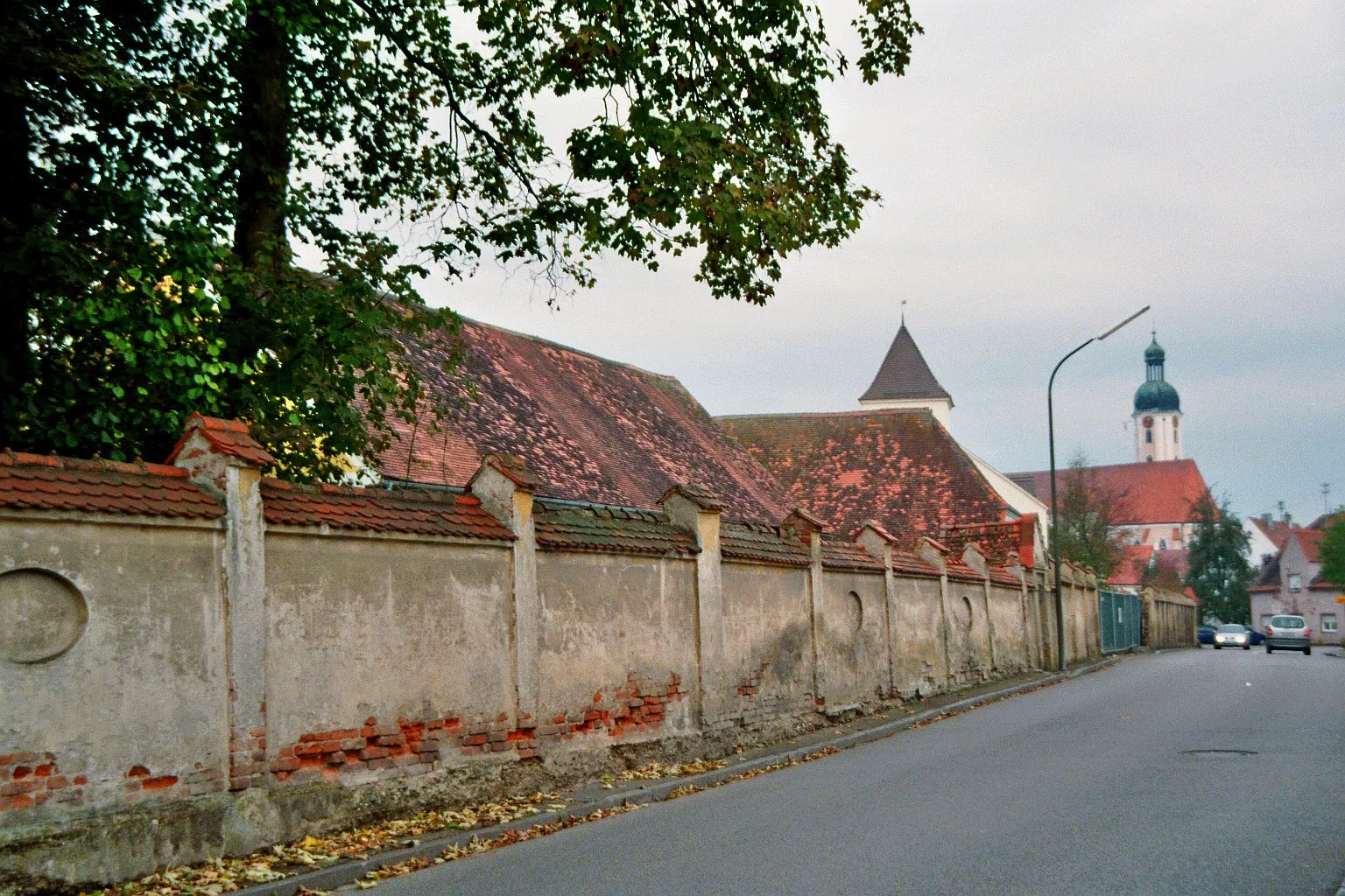 Photo showing: Aichach Street (Aichacher Straße) in Pöttmes, District Aichach-Friedberg, Bavaria, Germany. In the background the eastern Market Gate and the Roman Catholic Saints Peter and Paul Parish Church (Pfarrkirche St. Peter und Paul).