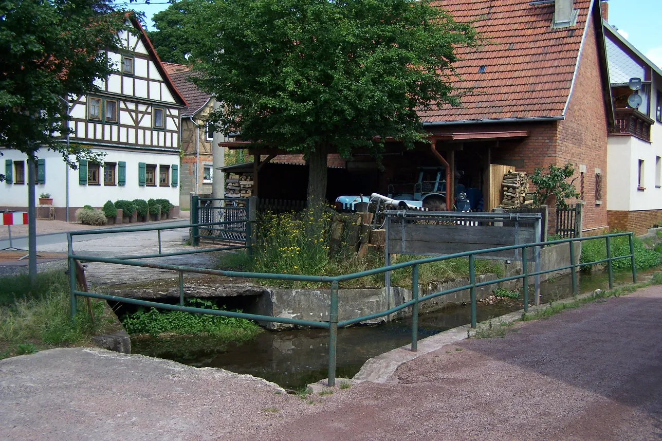Photo showing: In der südlichen Ortslage von Schweina: Einmündung eines Mühlwassers in den Schweina-Bach, etwa 100 m südlich der Kirche.