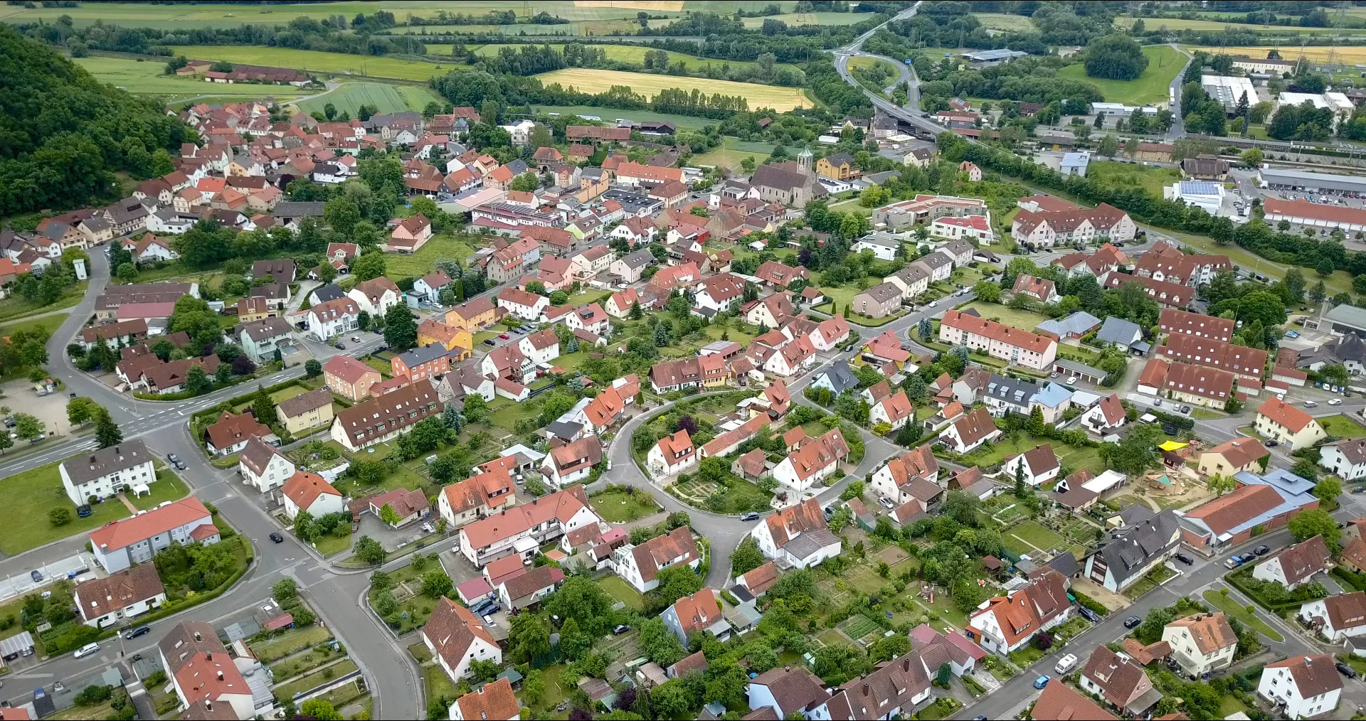 Photo showing: In dieser Drohnenaufnahme ist der Ortskern von Norden aus fotografiert. Links der Ausläufer des Ebelsbergs, am oberen Bildrand der Main, rechts die Bahnhof, Bildmitte oben die Kirche.