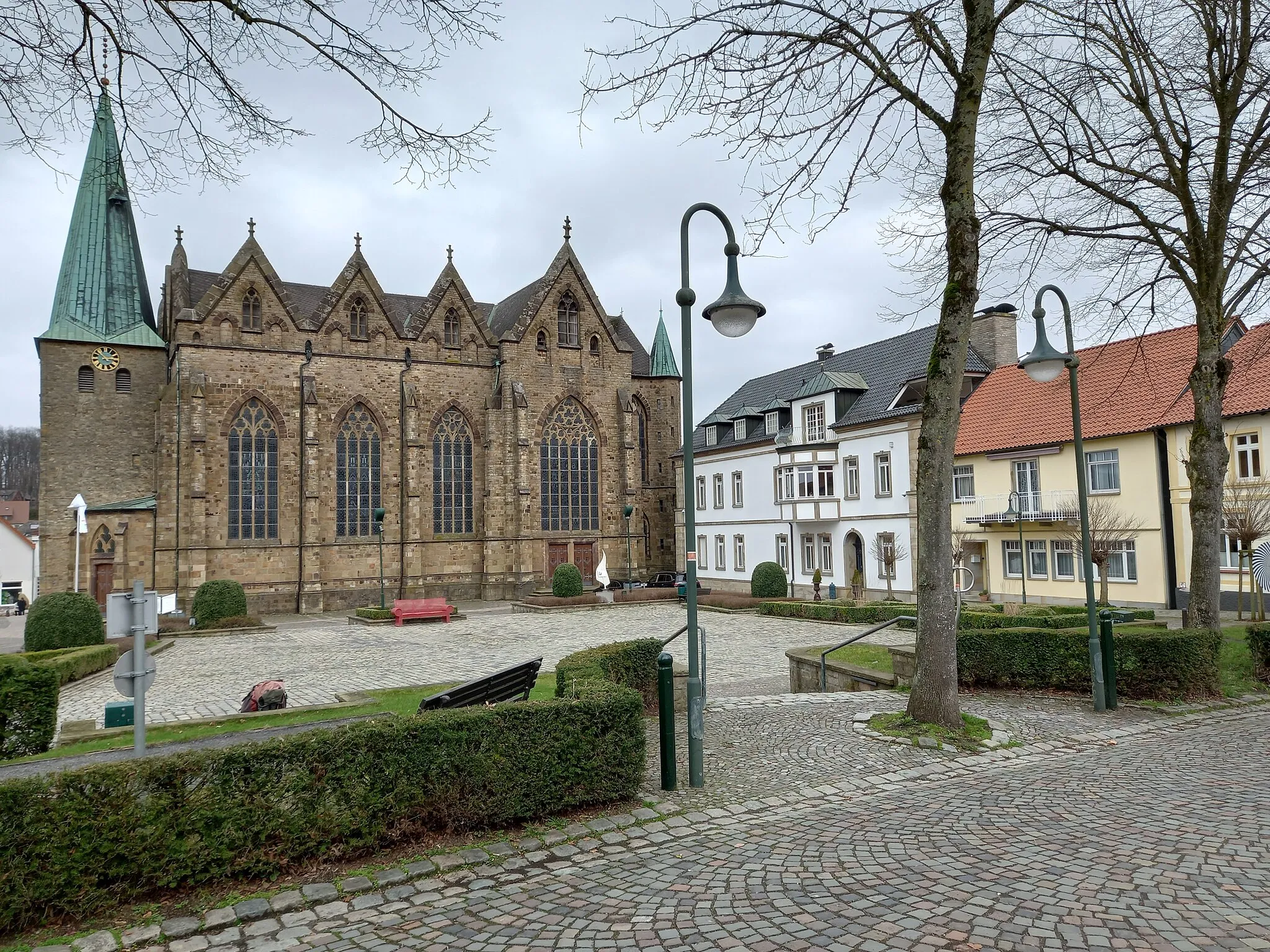 Photo showing: Pfarrkirche St. Lambertus und Häuser auf der Nordseite des Kirchplatzes in Ostercappeln (ehemaliger Landkreis Wittlage, heute Landkreis Osnabrück)