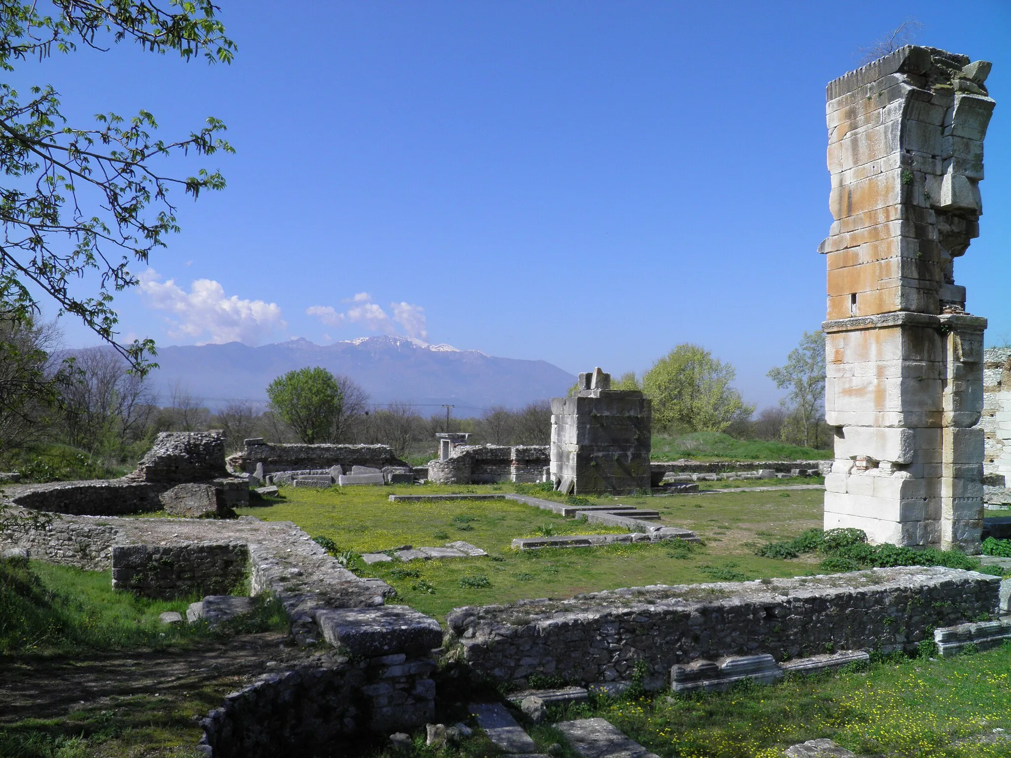 Photo showing: In the VIth century the inhabitants of Philippi embarked on the construction of an imposing basilica on the site of the town's palaestra; the size of the planned building clearly exceeded the needs of the town, thus indicating that Philippi attracted many pilgrims.
There is uncertainty among archaeologists whether the gigantic pillars of the basilica ever supported a dome; in 547 the so-called Justinian plague devastated the countries of the Mediterranean basin and in the early VIIth century an earthquake struck the region of Philippi; these two catastrophic events could have halted the completion of the basilica.
The decoration of the basilica moved away from classic patterns; all representations of human beings and animals were banished and even the acanthus leaves of Corinthian capitals were depicted in an almost symbolic way; this type of "combed" capitals can be observed also at many Byzantine locations in Syria of the same period.

The basilica was at the centre of a complex of buildings which included a chapel reserved to the bishop and a baptistery; the whole complex was built with materials taken from ancient monuments, but the stones were completely reworked in order to eliminate all references to gods, human beings and animals.