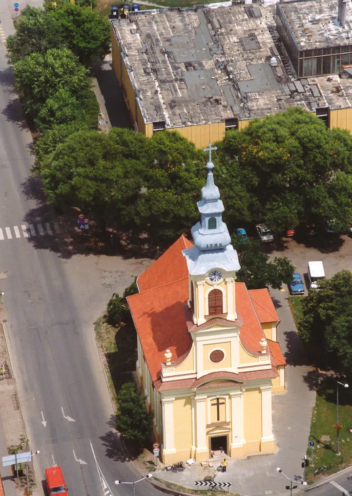 Photo showing: R.k. Szentháromság templom. Műemlék ID 2395 Copf stílusú, épült 1792-95 között, főhomlokzatán a bejárati tengelyt szegmensívű timpanonos diadalív koronázza, tornya a karzat fölött áll. Párnatagos toronysisakkal. Belsejében 4+1 csehsüvegboltozat, egységes copf berendezés. A stációkat és a Krisztus megkeresztelése képet Orlay Petrics Soma készítette. - Békés m., Békés,	Széchenyi tér