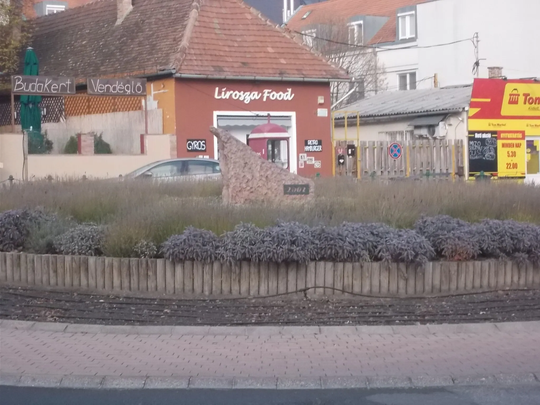 Photo showing: Roundabout with memorial stone (2002) - Szabadság Road (Route 1), Károly király Street, Historical city center neighborhood, Budaörs, Pest County, Hungary.