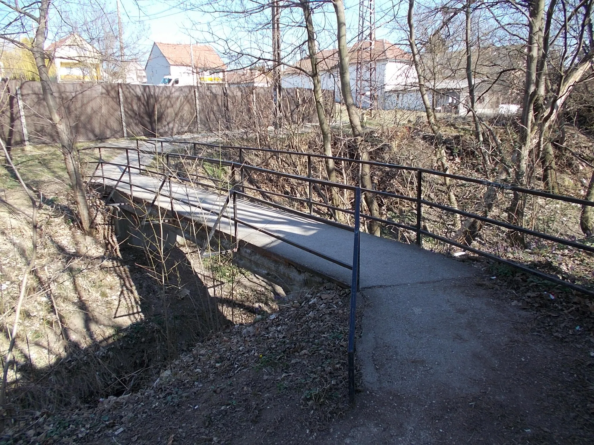 Photo showing: Béke Street? Footbridge over Kanyargos Creek (Kovács Creek). Part of Countrywide Blue Tour (abbr. OKT) section 15 /subsection OKT-152/ blue mountain bike trail close to Malom Street, Pilisszentkereszt, Pest County, Hungary.