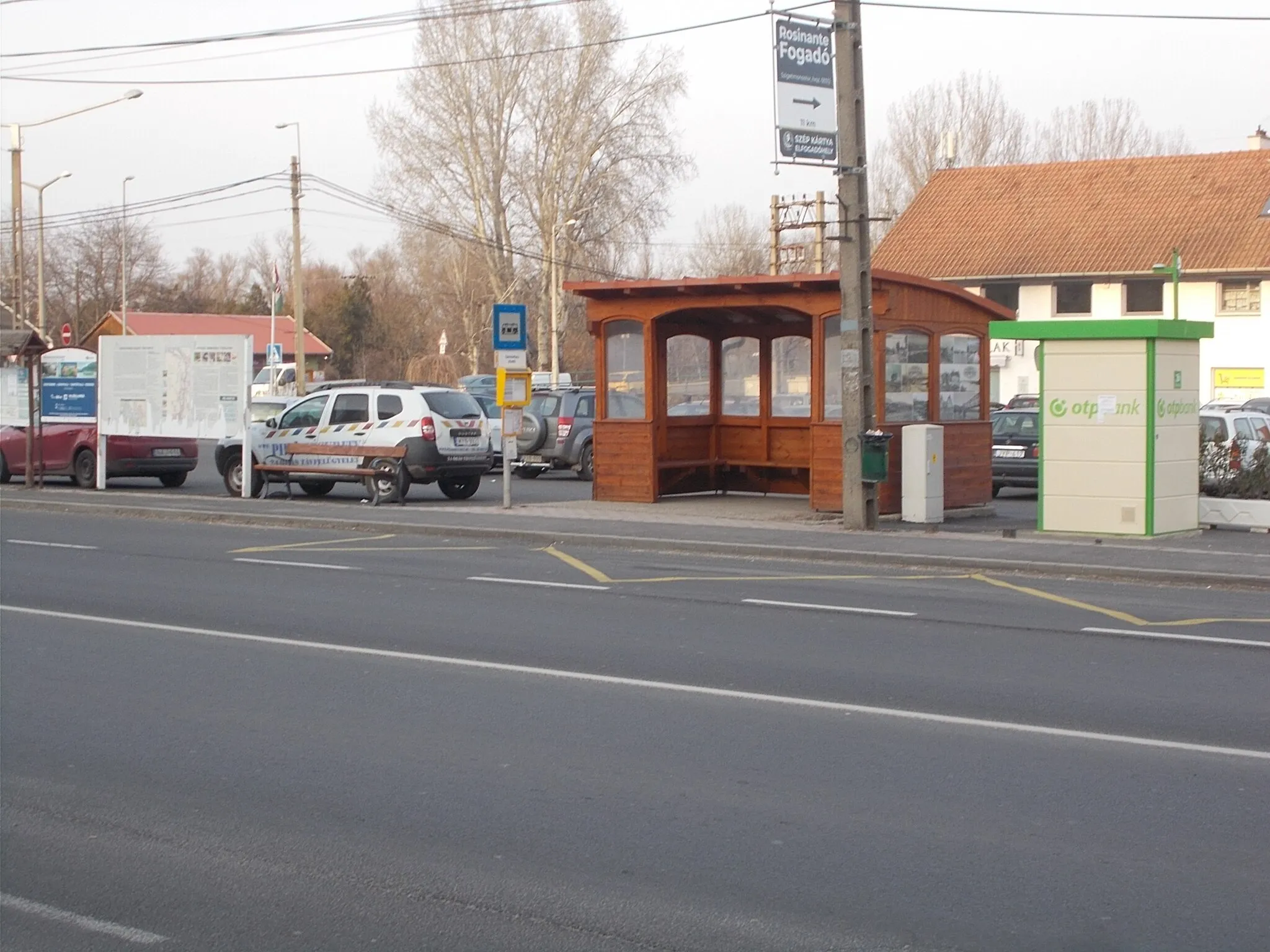 Photo showing: Information board about Szentendre Island, Pilis Security Dacia Duster car, OTP Bank ATM and 'Tahitótfalu, Hídfő' bus shelter (lines 880, 882, 883, 884, 889, 890, 893, 895, 898) with "Tahitótfalu Anno" photography exhibition (photos: circa 1900s to 1970s). About the information board: 'History of Szentendrei Island' (1st theme) At the time of the conquest, traditional pastoralism was carried out on the island. In the early Middle Ages, the Danube Bend was the center of the country, later it became Buda. The island served as a liaison between the two places. In addition to chin farming, they were also engaged in floodplain farming, shipbuilding, fishing and transportation. By the end of the Ottoman perion (17th century), the island's current 'settlement network' was formed. In the 1870s, the first Hungarian Bulgarian horticulture was founded on the island. The sandbagged areas of the island were tied up with acacias and tied up. From the 1850s, the island, famous for its beaches, becomes (partially) a recreation area. From the beginning of the 20th century, the flood protection system of the island is being built. The current dams of Tótfalu were built in 1971. The first Tahi-lake village bridge was completed by 1914. Tildy Zoltán Bridge with its current reinforced concrete structure Tildy Zoltán Bridge was completed in 1978. - In the 1890s, the first water wells of the Metropolitan WaterWorks were built. In the 1970s, the current network of water wells, large-diameter aqueducts and control centres was developed to provide water for nearly two million people. The island has a length of 33km, a width of 3.8km and an area of about 58sqkm and part of it belongs to the Danube Ipoly National Park. - AND 2nd theme ' Valuable natural areas on Szentendre Island': 1. Island peak, valuable willow and poplar stock; 2. Kisorosi golf course; 3. Mártuska Island (protected since 1974) floodplain grove forest native to willows and poplars, an important bird migration resting place natural bird habitat (reed warbler, kuvik, cat owl, ducks; on migration: gray heron, stone lark, dwarf lark ) 4. Pankúti pasture and Goat Island (protected since 1978) floodplain levels of different heights, grasslands, floodplain grove forest with remnants of herbaceous plant species, in wet meadows snake tongue fern and summer peduncle, yellow female petals, spring starflower scouting orphan-haired sand wasteland meadows, ashy and meadow hawk and meadow shell feeding place 5. The area around Goat Island is a floodplain reef backwater. 6. Turda Island (protected since 1978): floodplain grove forest remnant birds kingfisher, beehive, Berk cricketbird, egrets, duck species, black stork, fishing eagle, crane, snake buzzard, raven; 7. Sand descent varied sand wastelands (foal's tail, sand kikerics, sand woman's petal , sleak-grass, ...). 8, Calvary Hill of Szigetmonostor, 9 Göd? island south peak, 10. 'Hegyköze', former military training ground, open and enclosed sand grasslands with characteristic fauna (owl moth, sandpiper grasshopper, sand italian grasshopper,) 11.Alsóderzsán?  artificial lake waterbird resting place (egret, stork,) - Geologically, the island's gravelly alluvial layer is clay at the bottom and sand at the top. Water from local wells is clean and healthy thanks to nature, and no treatment other than chlorination is required - Szentendrei Road (Road), Tahitótfalu, Pest County, Hungary.