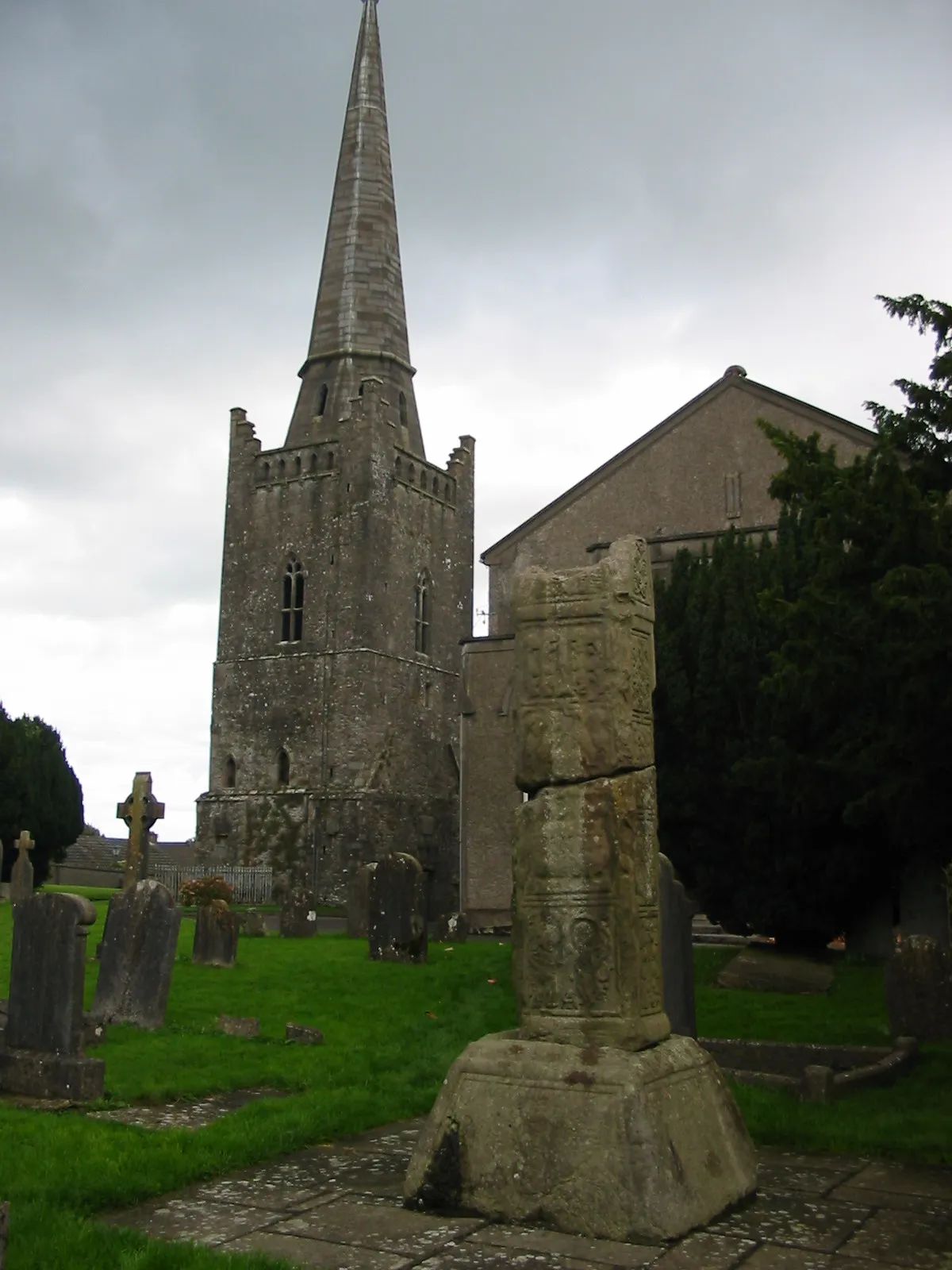 Photo showing: The Broken Cross is one of the five high crosses in Kells, County Meath, Ireland. It may have been the tallest high cross ever. It may have been broken by Oliver Cromwell's army, which used the church as stables. Here is a south-west view, with behind St Columba's Church.