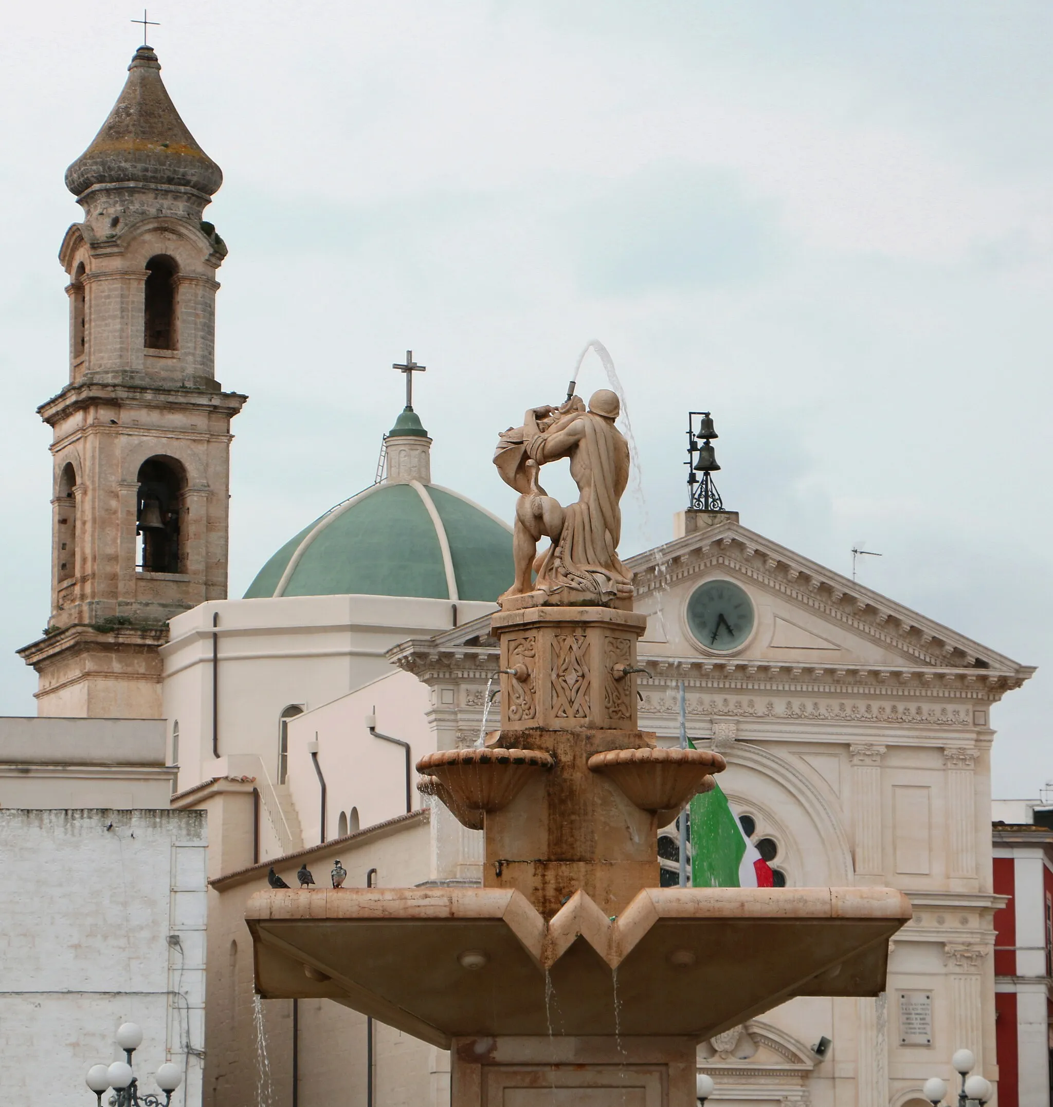 Photo showing: The center of Mola di Bari is considered Piazza XX Settembre, best represented by the Monumental Fountain, known as "bath" and the Church of the Magdalene