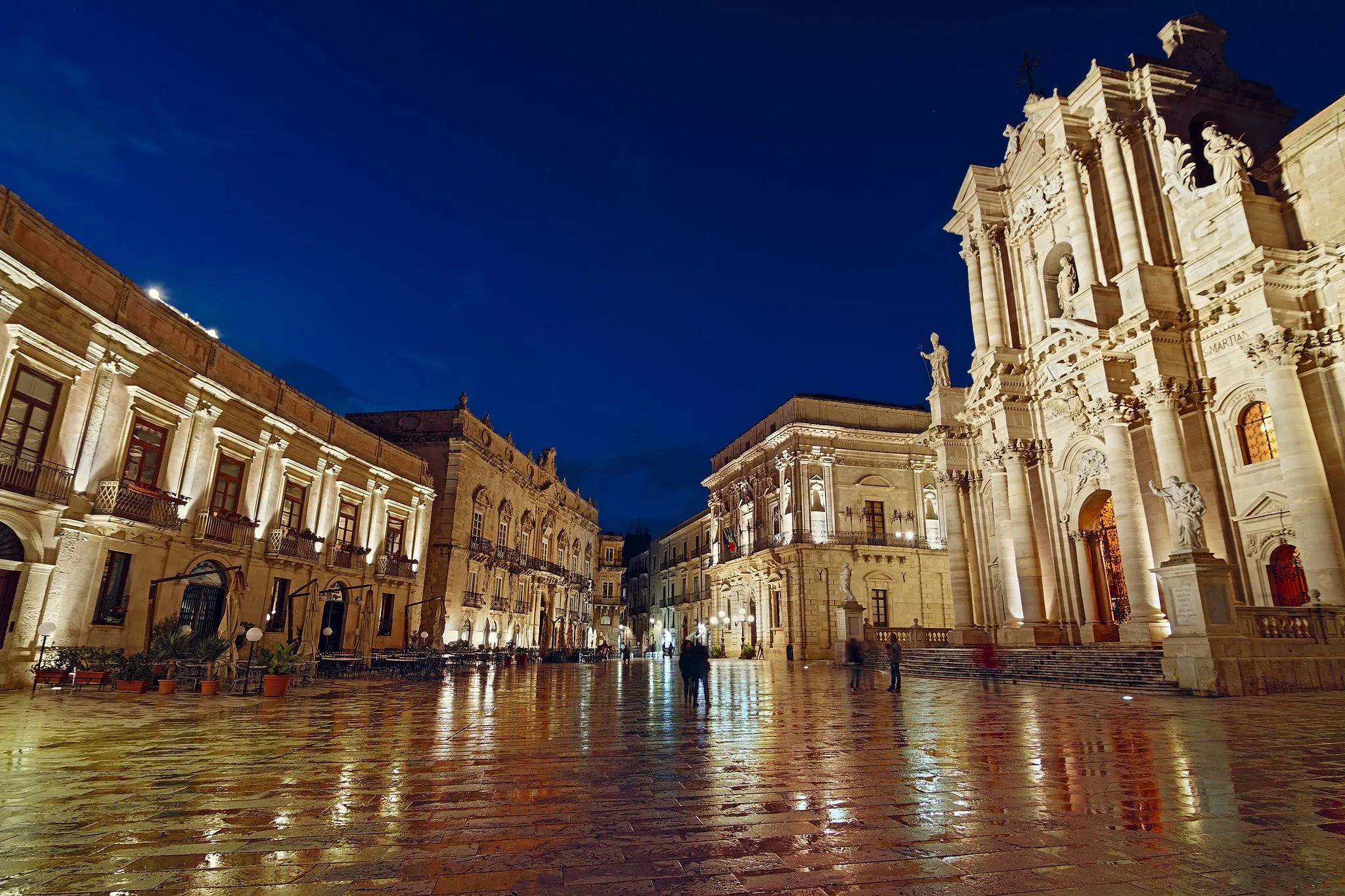 Photo showing: Piazza Duomo (Syracuse - Unesco World Heritage) during the blue hour. Few minutes before the shot,  the plaza got wet becouse of the rain. it did not last long but the effect was incredible. The stones reflected all the colors from the natural and artificial lights.