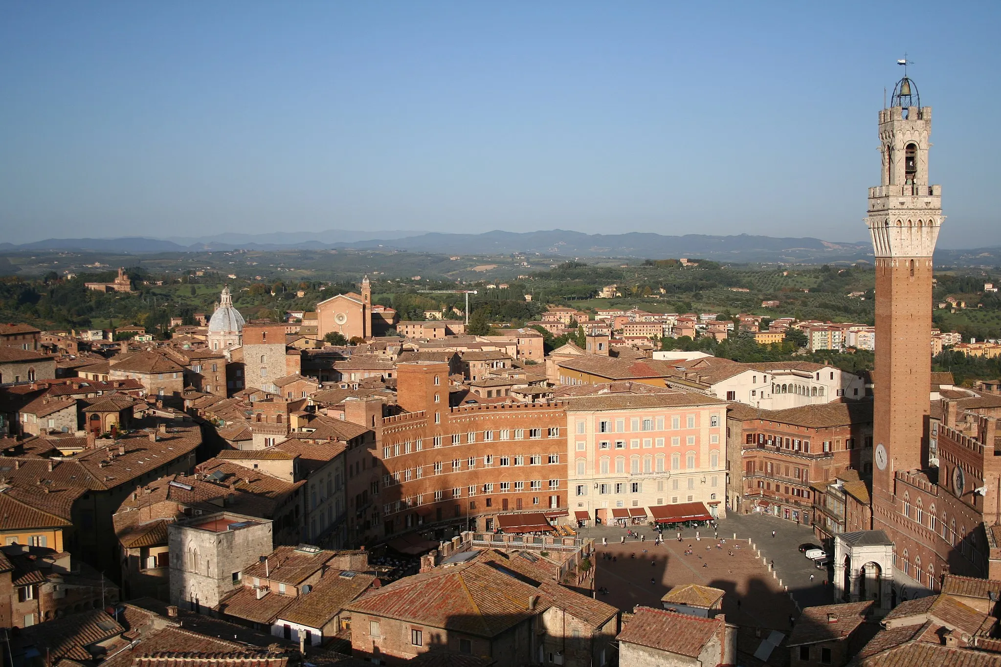 Photo showing: A photograph taken of the Piazza del Campo in Siena with tower Torre del Mangia and landscape with hills in background.