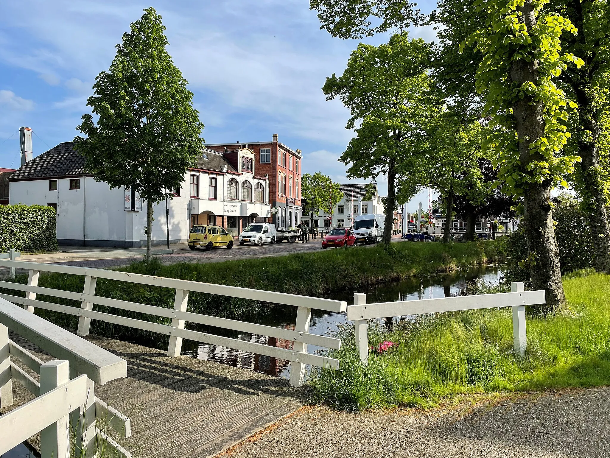 Photo showing: The Brinkstraat in Oosterwolde (Friesland, Netherlands) seen from the Quadoelenweg, with a footbridge over a branch of the 'Opsterlandse Compagnonsvaart'-canal.