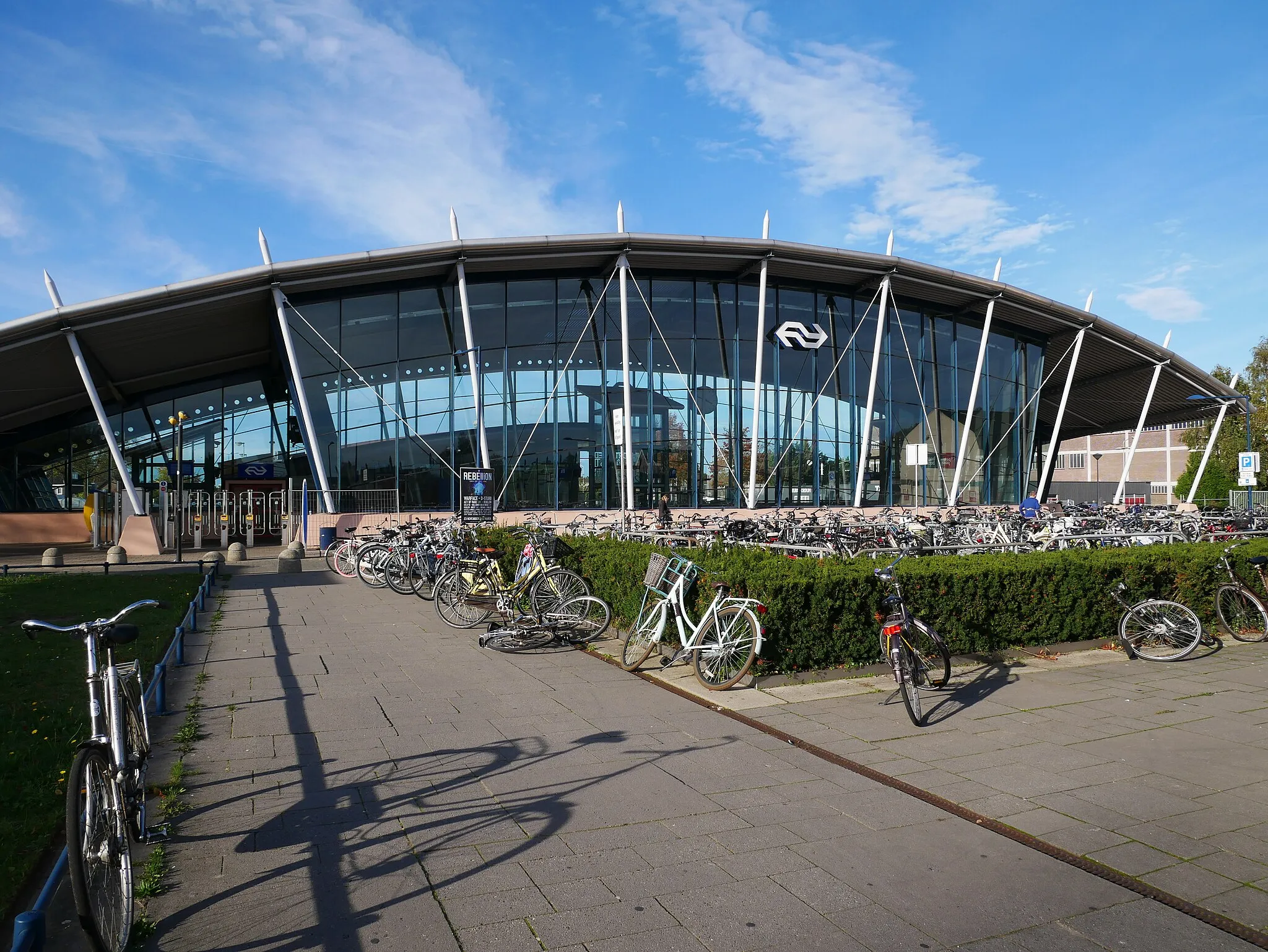 Photo showing: The station building of Best railway station and a bicycle parking station in front of it