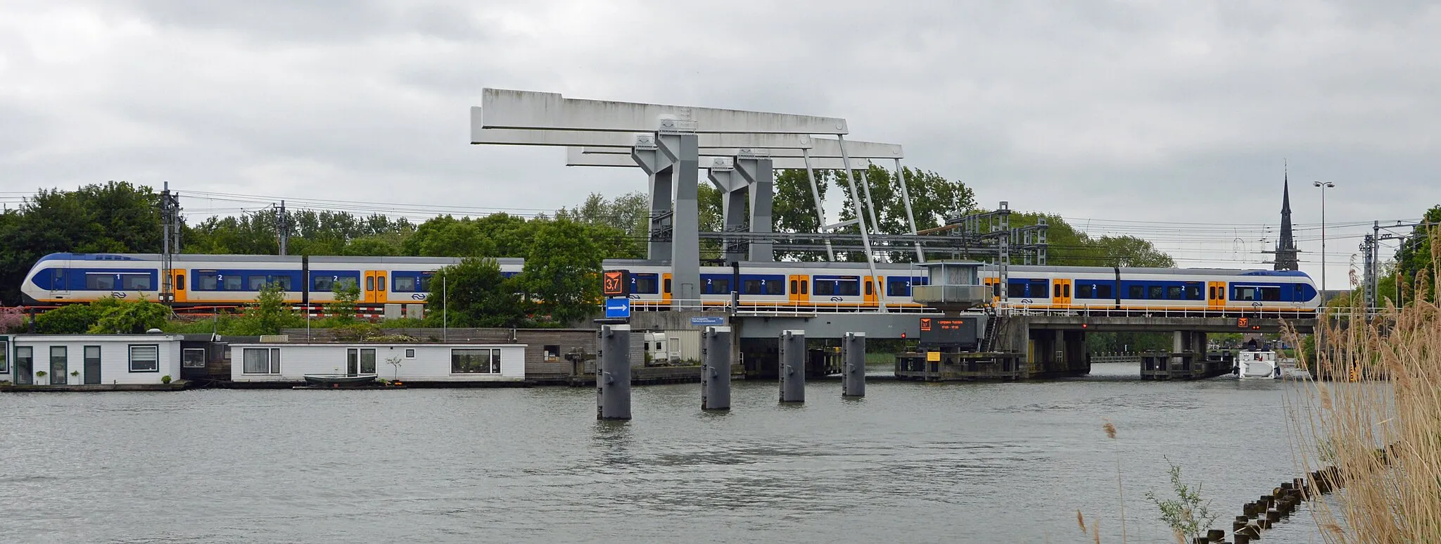 Photo showing: A Sprinter train to Schiphol Airport and Hoofddorp passes the bridge over the Vecht in Weesp, near Amsterdam.