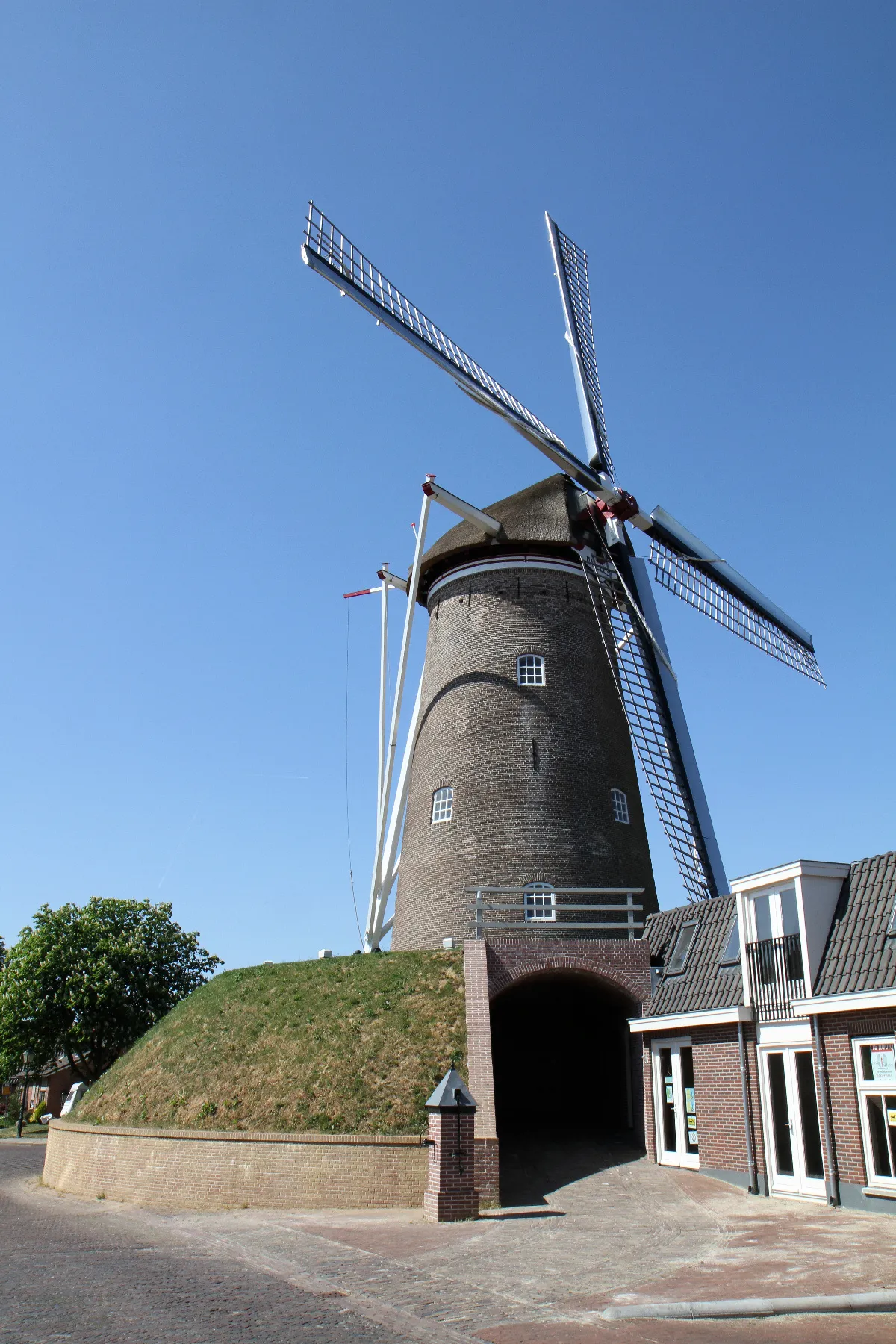 Photo showing: en:Amerongen: Windmill Maallust. The name can be translated both as Lust of Milling and Lust at Milling. This round brick en:gristmill was built in 1830. From 2007 tot 2009, this beltmolen (mill on a mound or hill) was restored and partially rebuilt from a state of disrepair, after being relocated over 17 meters. After the restoration it is used again for grinding flour, albeit on a small scale. The mill is at the Molenstraat, the houses are at the Burgemeester Jonkheer H. van den Boschstraat. Their low en:gambrels are designed to provide a free windflow to the mill.