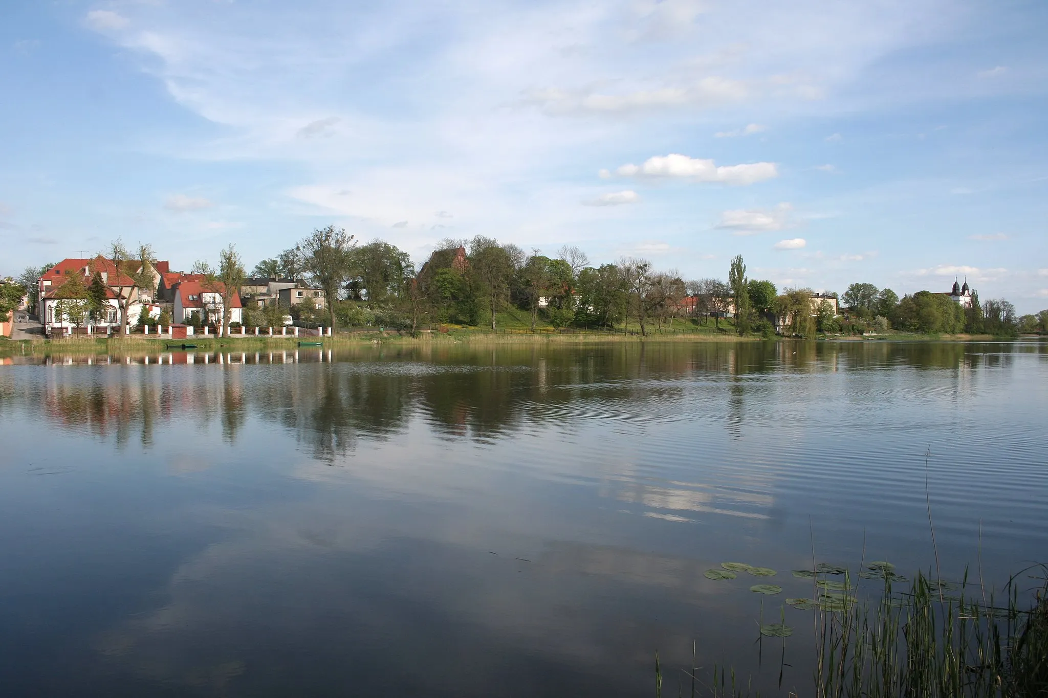 Photo showing: Mogilno, panorama of the city from west bank of Mogileńskie Lake. In the center the church of St. James, on the right church of St. John.