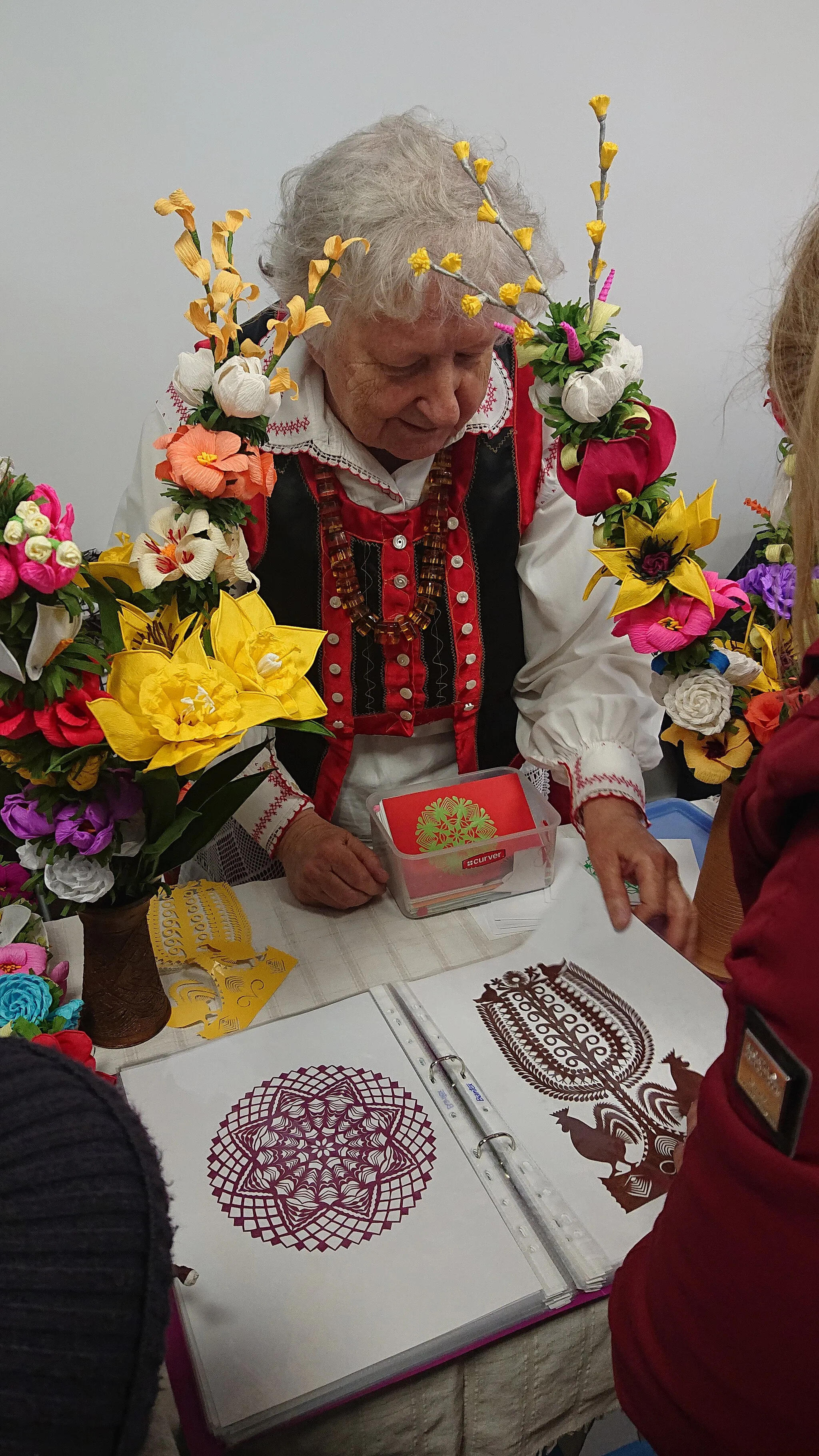 Photo showing: Czesława Marchewka prezentuje swoje wycinanki na kiermaszu z okazji Niedzieli Palmowej w Łysych