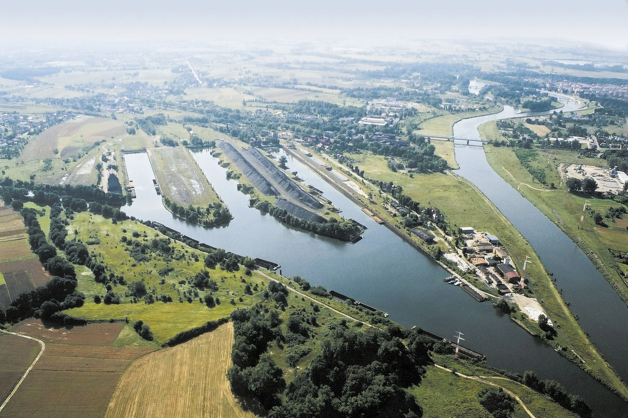 Photo showing: The port of Koźle. The picture shows the mouth of the Gliwice Canal (on the left) to the Oder, disappearing in the bank line. Behind, on the right, the lock of Koźle on the Oder.