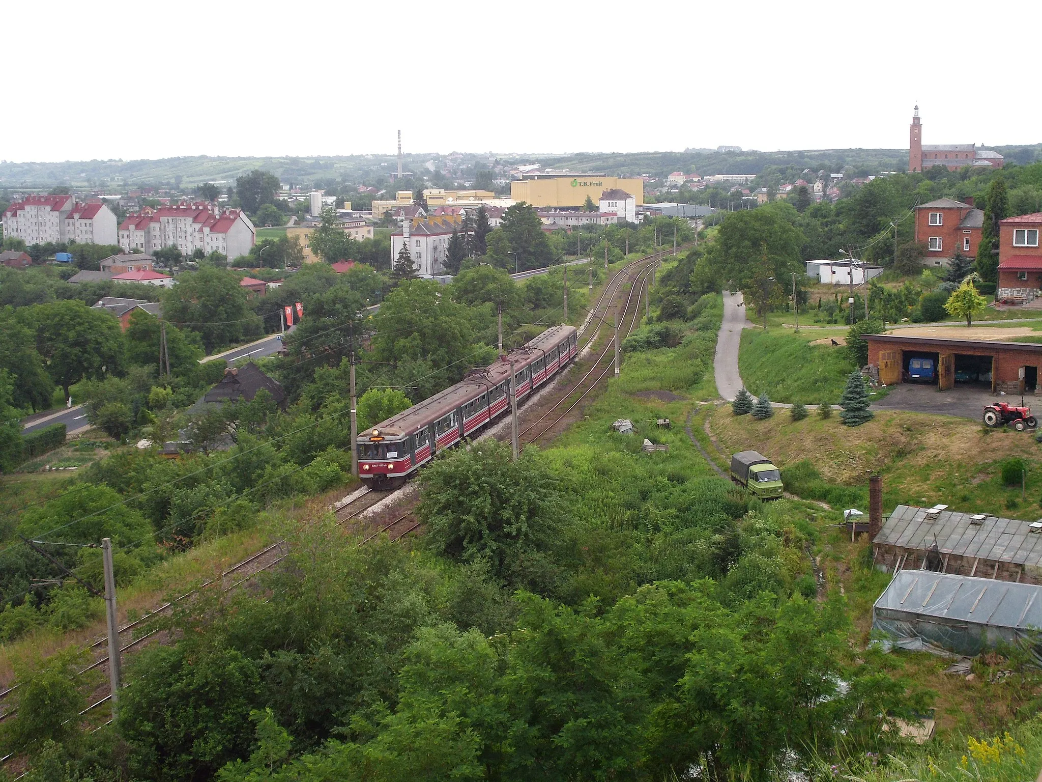 Photo showing: Panorama of Dwikozy, Poland, from a hill roughly North-East of the city. Railway route 25 (Dwikozy - Stary Garbów) with EN57-005rb runs below.