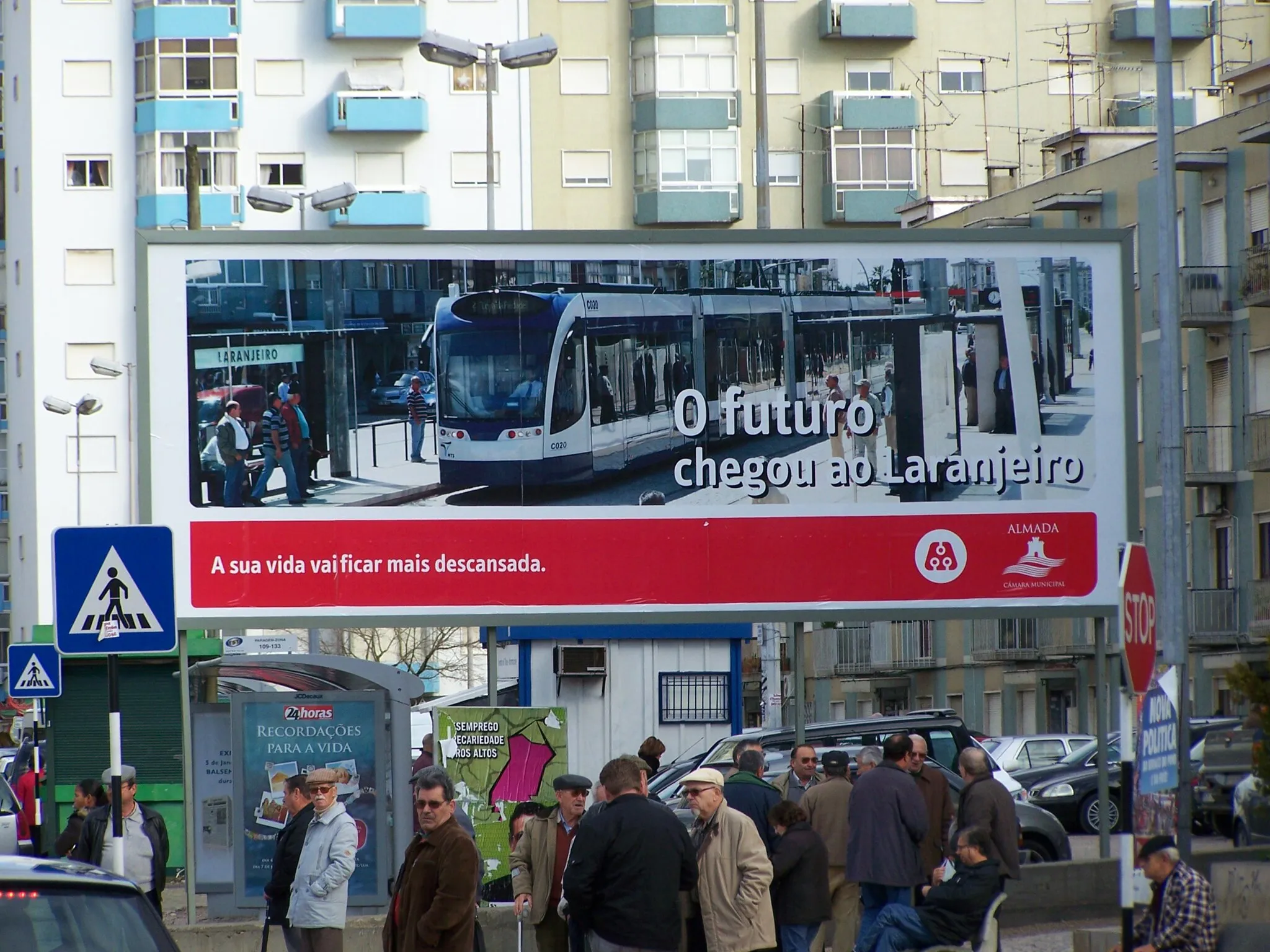 Photo showing: Advertisement for the new tramway system "Metro Sul do Tejo" in Laranjeiro, Almada, Portugal. Siemens Combino Plus tram (#C020), built 2007, on the advertisement.