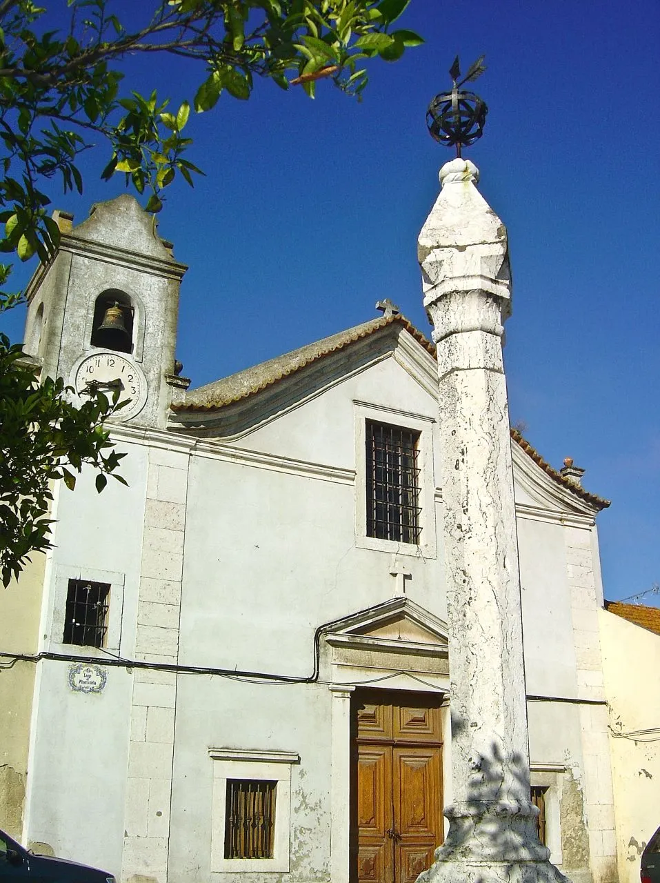 Photo showing: Alhos Vedros é uma das mais antigas localidades da margem Sul do curso terminal do Tejo. A primeira referência conhecida a seu respeito data de 1298, ano em que se documenta já a sua igreja, dedicada a São Lourenço. Por essa altura, a vila era uma das duas sedes de freguesia do antigo concelho de Ribatejo - a par da extinta Sabonha, depois transformada em São Francisco no século XVII e hoje integrada no concelho de Alcochete -, e estava vinculada à Ordem de Santiago, que aqui possuía comenda.
Por estes dados, tem-se sugerido que as origens do povoamento de Alhos Vedros se tenha verificado imediatamente após a conquista de Lisboa, Almada e Palmela, de 1147, evoluindo à medida que a Ordem de Santiago tomou posse das terras e as pretendeu desenvolver economica e populacionalmente.
O pelourinho não data de tempos tão recuados, mas evoca ainda os tempos em que Alhos Vedros foi sede do território circundante. A sua construção deve situar-se pela segunda década do século XVI, imediatamente após a concessão de foral, passada por D. Manuel a 15 de Dezembro de 1514.
De facto, são vários os elementos manuelinos que podemos encontrar nesta obra, reveladores de grande homogeneidade cronológica e artística. O principal (pelo maior impacto visual que tem), é o primeiro degrau em que se assenta o monumento (dos três ue formam a plataforma), de perfil circular e decorado com "grosso calabre ao jeito manuelino" (MALAFAIA, 1997, p.83), de duplo toro entrançado. Segue-se a base, quadrangular, mas de moldura octogonal de faces reintrantes, tão característica das bases de colunas e de arquivoltas dos portais das primeiras décadas do século XVI. O fuste é monolítico e octogonal, terminando num pequeno capitel tronco-piramidal antecedido por dupla moldura. O coroamento é relativamente simples, com peça única de terminação piramidal, sobre a qual se apoia uma composição de ferro, com esfera armilar e uma seta orientada para Ocidente.
Localizado na principal praça da vila, confrontando com as propriedades da Misericórdia local, o pelourinho é a marca distintiva do antigo estatuto de Alhos Vedros como sede municipal, prerrogativa extinta em 1855, altura em que passou a integrar o concelho da Moita. Ainda antes, em 1834, a vila deixara de ser propriedade da Ordem de Santiago, facto que se revelou decisivo para a integração desta parcela de território na unidade centralizada a partir da Moita.
Só muito recentemente o pelourinho foi alvo de alguma atenção. Classificado em 1933, data de 1980 o arranjo do espaço envolvente, com definição de um jardim na direcção do Hospital da Misericórdia e das traseiras da Igreja Matriz, beneficiação urbanística que se revelou fundamental para uma maior monumentalidade da obra.
PAF www.ippar.pt/pls/dippar/pat_pesq_detalhe?code_pass=74755

See where this picture was taken. [?]