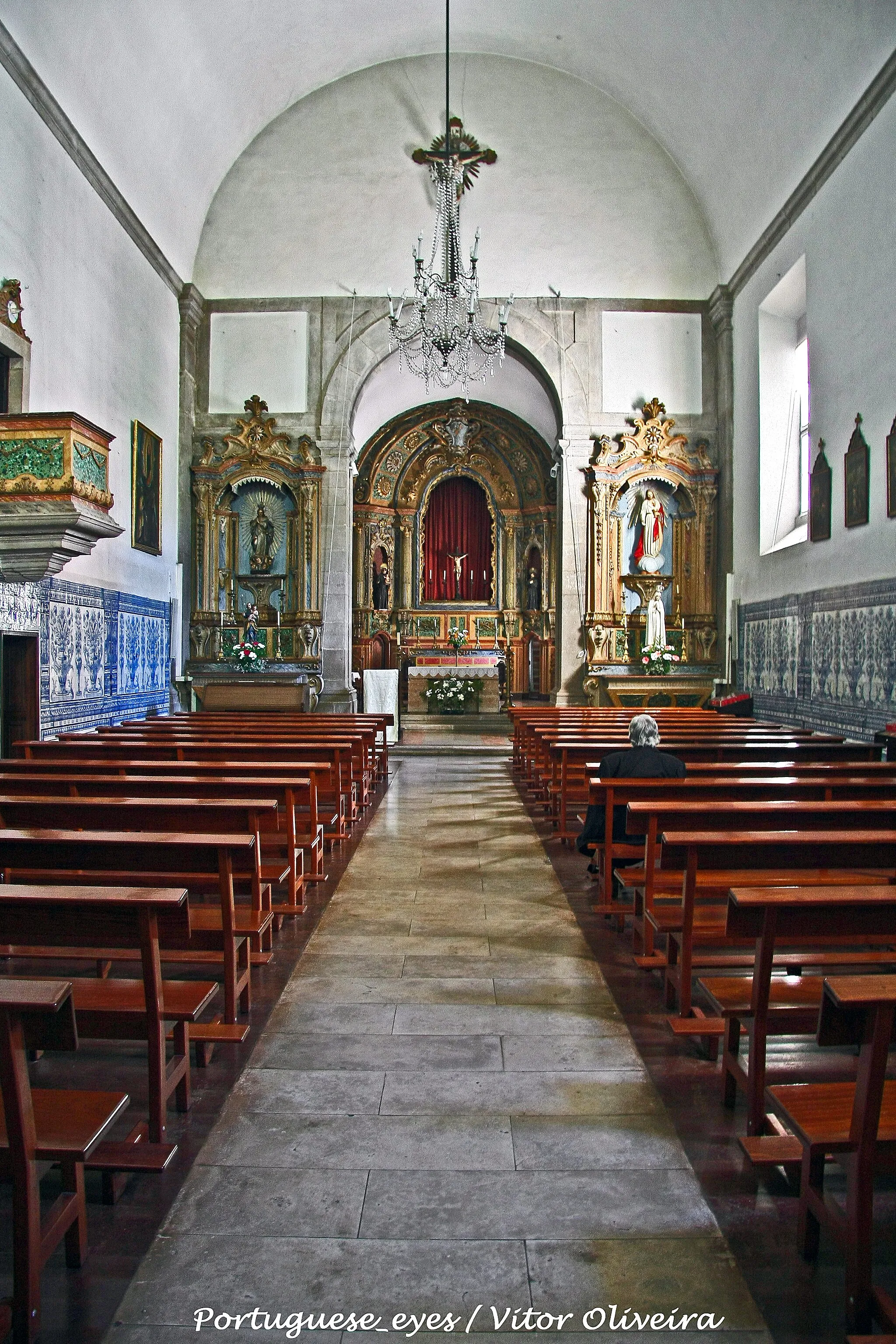 Photo showing: A Igreja do Convento de Santo António da Lourinhã ou Convento Santo António da Lourinhã situa-se na freguesia da Lourinhã, na vila da Lourinhã, em Portugal. Situado na parte baixa da vila, o ex-convento de frades recoletos, da ordem franciscana, é um edifício começado a construir em 1601, em estilo clássico.
História
O convento era inicialmente constituído por uma pequena igreja, e em 17 de Novembro de 1601, iniciaram-se obras de ampliação que se prolongaram por vários anos, devido à grandeza e volume do edifício e às dificuldades monetárias dos frades.
É classificado como Monumento Nacional desde 1910.
Características
Possui um pequeno claustro, de dois pisos, com colunas que sustentam capitéis da ordem toscana. O claustro inferior possuía um lambril de azulejos dos primeiros anos do Século XVIII, representando meninos com cabazes de flores à cabeça, que ainda se podem admirar numa das paredes, estando nas restantes réplicas mandadas fazer a quando do último restauro.
A igreja, de uma só nave, tem sofrido grandes restauros que a desfiguraram, especialmente na sua fachada.
A capela-mor é separada do corpo da igreja, por um duplo arco sustentado por pilastras da ordem toscana.
A nave, de abóbada de berço possui um largo silhar de azulejos, da segunda metade do Século XVIII, de albarrada.
As paredes da capela-mor são forradas com painéis de azulejos figurativos, azuis e brancos, do Século XVIII, época da construção do retábulo do altar-mor e dos altares laterais.
No lado do Evangelho, abre-se em arco renascentista o túmulo de D. Brás Henriques, mandado construir pela sua viúva, D. Brites Brandoa e sob risco do arquitecto régio Pedro Nunes Tinoco.
Ao fundo da nave, no lado da epístola, a pequena capela mandada erigir em 1714, conforme consta numa cartela, pelo Padre João Nunes Franco, Beneficiado da Matriz, para seu jazigo. O retábulo do altar e em mármore florentino e a revestir o altar e as paredes dois painéis de azulejos com cenas de milagres de Santo António, do ciclo dos mestres e atribuídos ao mestre que costumava deixar apenas as iniciais P.M.P.

See where this picture was taken. [?]