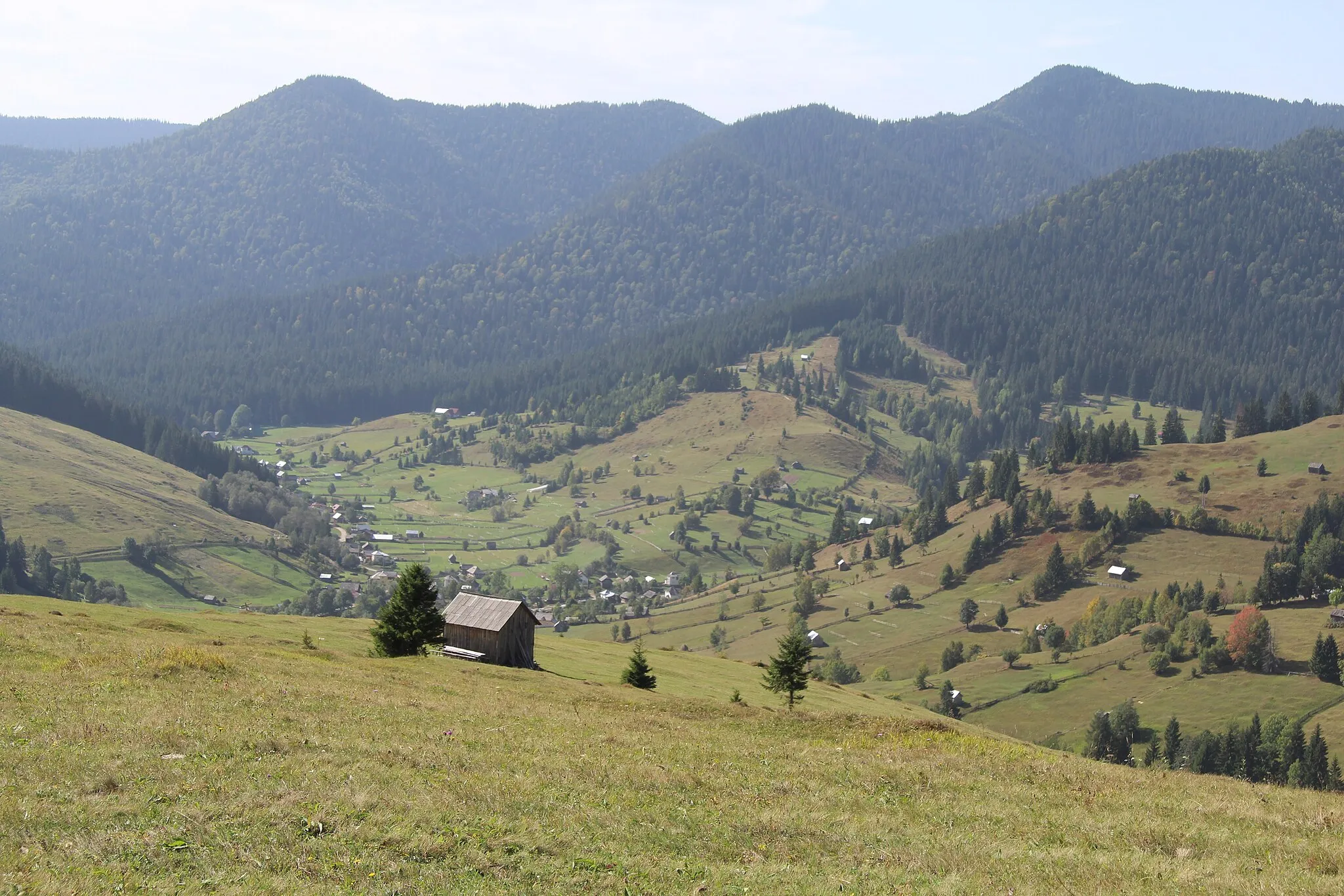Photo showing: Blick von einem Bergrücken hinunter zum südwestlichen Teil des langgezogenen Ortes Slatioara bei Campulung Moldovenesc, Kreis Suceava, Rumänien