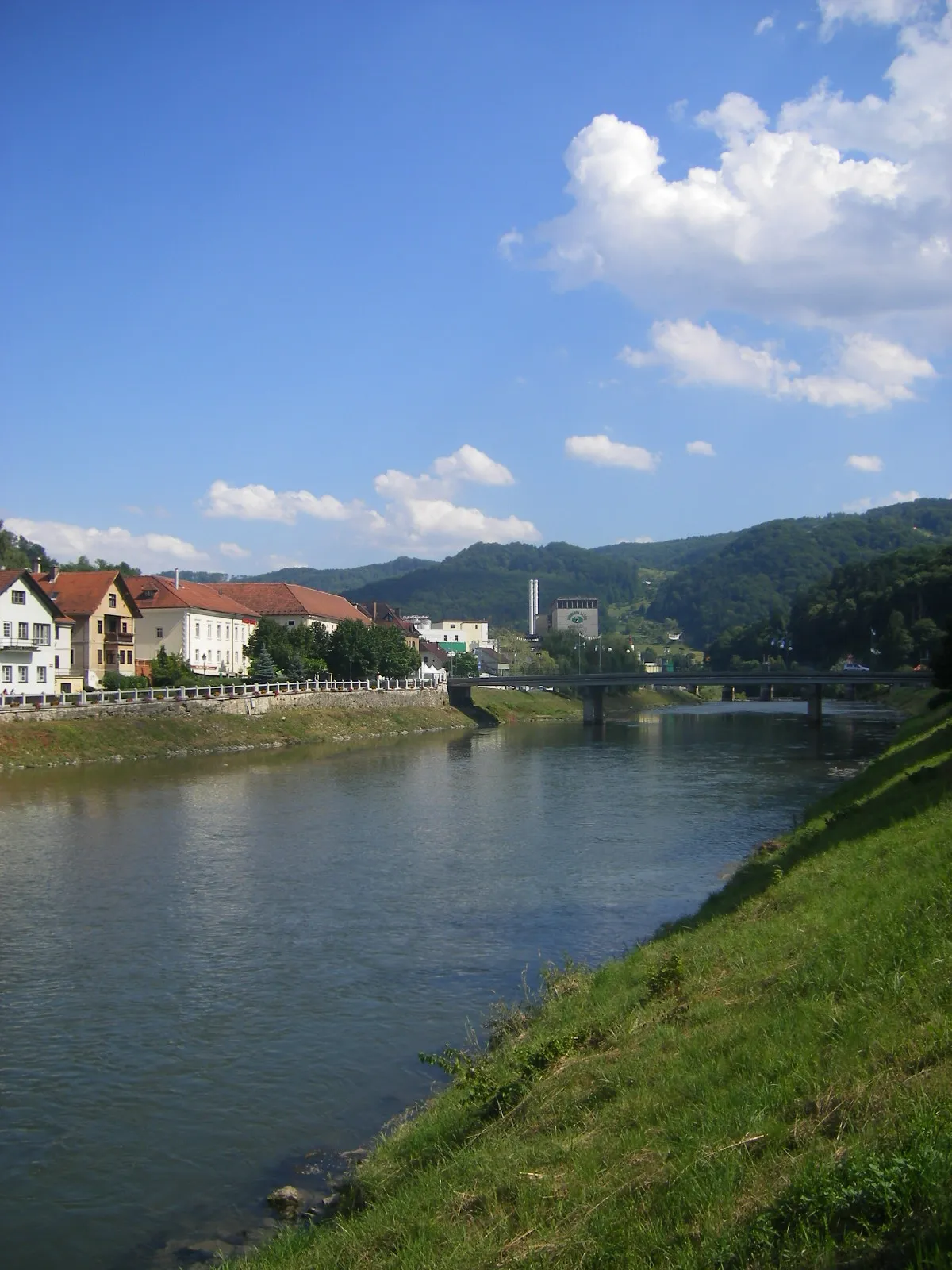 Photo showing: Laško - Savinja River. Far behind is the Laško Brewery (Pivovarna Laško).
