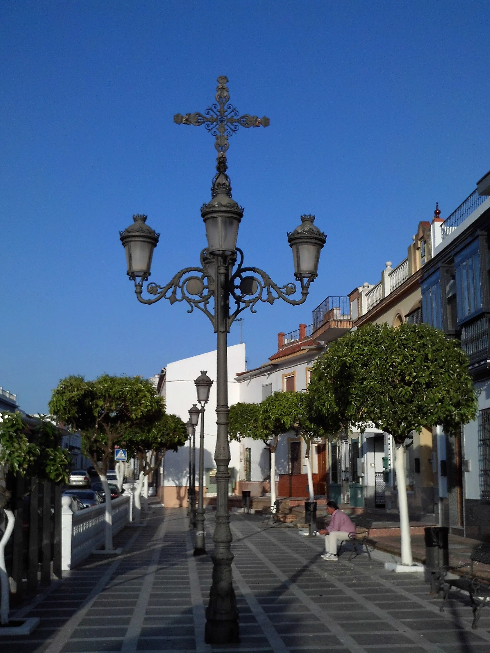 Photo showing: Farola fernandina de cuatro brazos con Cruz encima en la Plaza de la Cruz, en la localidad de Espartinas