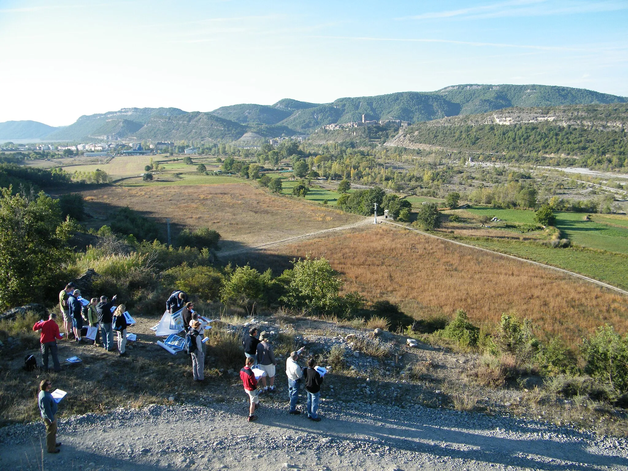 Photo showing: A party of geoscientists study turbidite channels in cliffside outcrops north of the ancient Spanish town of Ainsa.