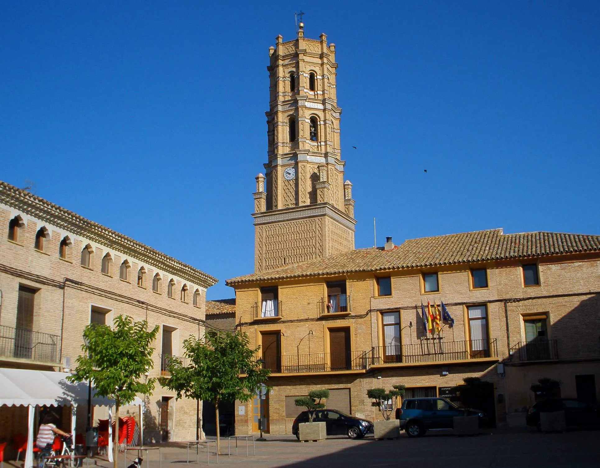 Photo showing: Plaza del Planillo, en Villamayor de Gállego. En el primer plano, el Ayuntamiento, y tras el mismo la torre mudéjar de la iglesia parroquial de la Asunción de Nuestra Señora
