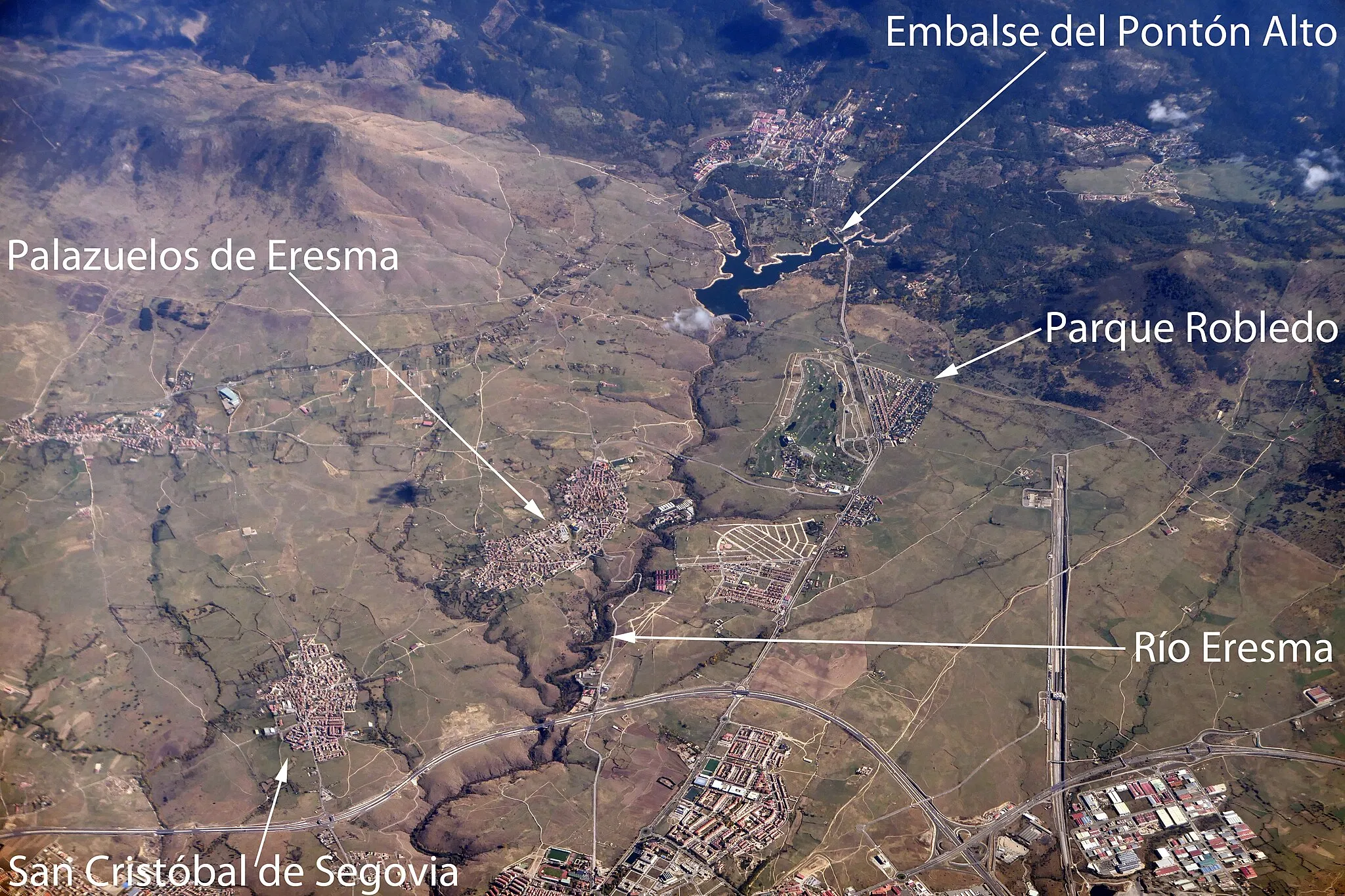 Photo showing: An aerial photo of the area just east of Segovia. Labelled are Palazuelos de Eresma, San Cristóbal de Segovia, the Embalse del Pontón Alto, Parque Robledo, and the river Eresma.