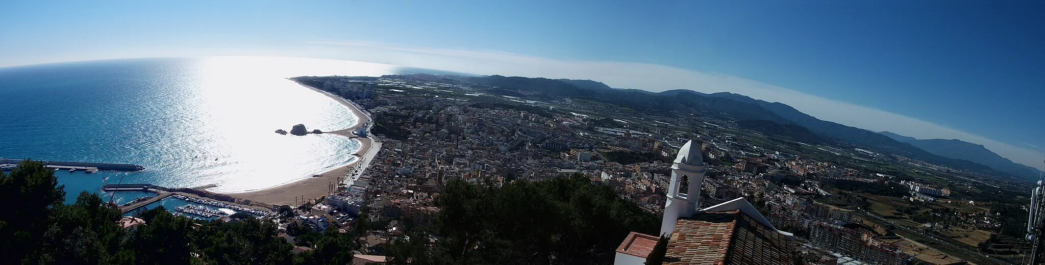 Photo showing: Imagen de Blanes desde el Castillo de San Juan. Se observa el mar Mediterráneo, desembocadura del río Tordera, sierras del Montnegre y Montseny, y pueblos del entorno (Tordera, Palafolls, Malgrat de Mar).