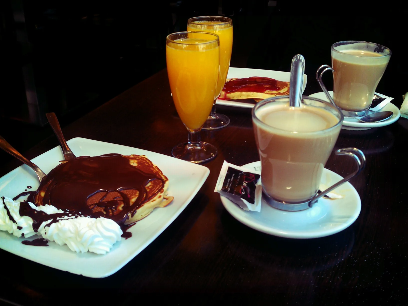 Photo showing: Desayuno de café cortado, zumo de naranja y tortitas.