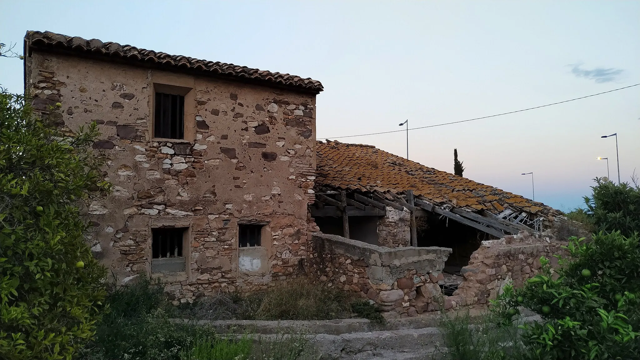 Photo showing: Junto con el Molí de Baix, forma parte de las antiguas propiedades del Conde de Faura. Este molino actualmente está sujeto al arrendamiento histórico por la familia Cueco. La maquinaria de moltura se conserva en buen estado, siendo la cubierta del mismo la que está completamente en ruinas, habiéndose derruido en varios puntos de la vivienda aneja. Trabajaba con el agua de las filas (cada una de las acequias separadas por un partidor o sistar) de Faura i Llogarets. Este molino ha funcionado solo por medio de la energía hidráulica hasta su cierre en el año 1950.