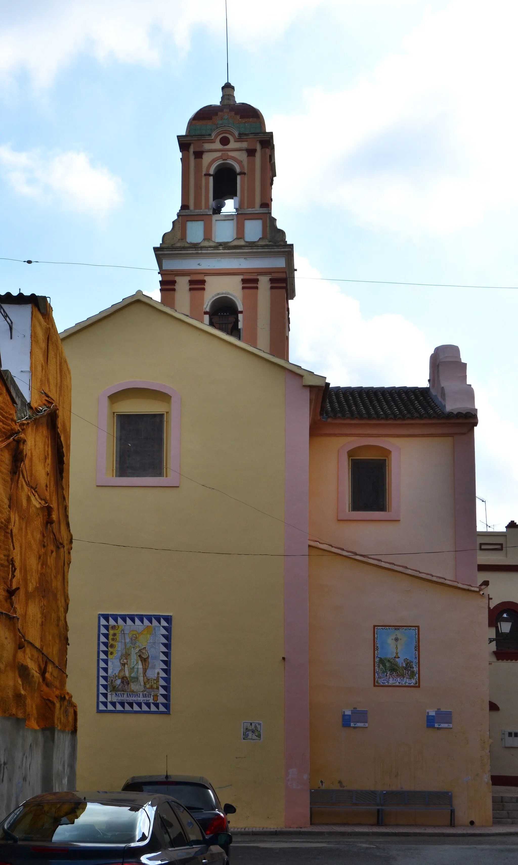 Photo showing: Església de sant Antoni Abat de Favara, lateral.
L'església va començar a construir-se en 1748 i s'acabà en 1760. D'estil neoclàssic, posteriorment fou realitzat l'ampliació del braç del creuer per situar la capella de la Comunió. La casa abadia, comunicada amb l'església, custodia l'arxiu des de 1621. L'interior presenta un estil neoclàssic, amb altars i decoracions pròpies d'aquest estil.