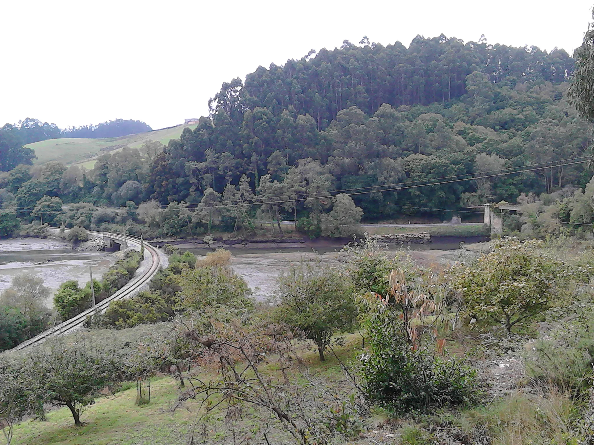 Photo showing: Desembocadura do río Grande na ría de Ribadeo, entre Santalla e Ove. Pódese observar a liña de ferrocarril de vía estreita Ferrol-Xixón, e á dereita, a ponte da antiga liña Ribadeo - Vilaoudriz, hoxe soporte para o tubo de auga que subministra Ribadeo. Á esquerda, a ría, e á dereita, o río Grande.