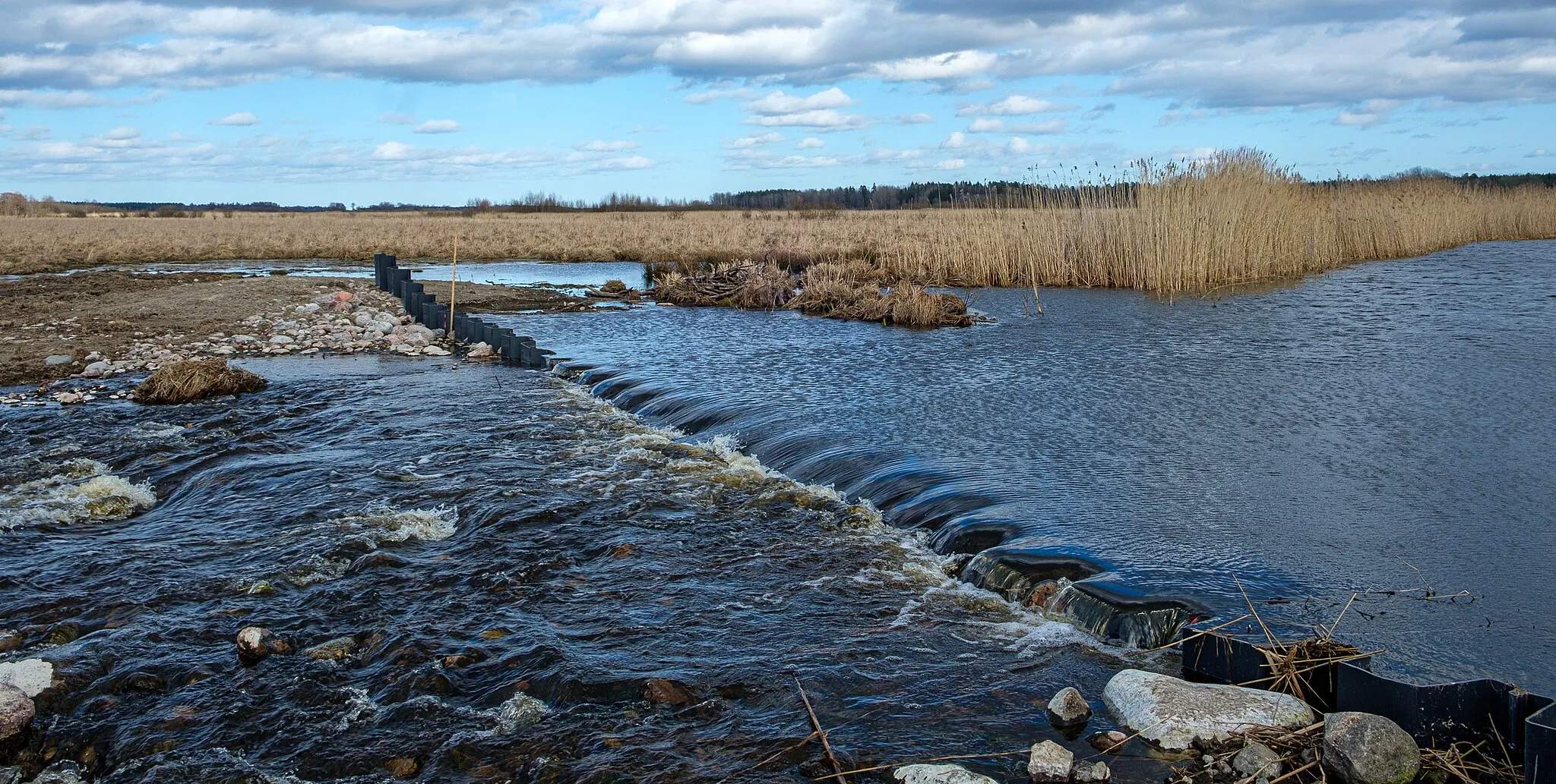 Photo showing: Vendelsjöns utlopp i Vendelån. Ett dämme reglerar sjöns yta enligt vattendom